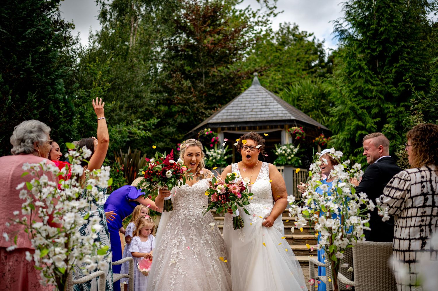 documentary wedding photography lgbt brides coming down the aisle confetti flowers emotion surprise smiling clapping happy amber springs
