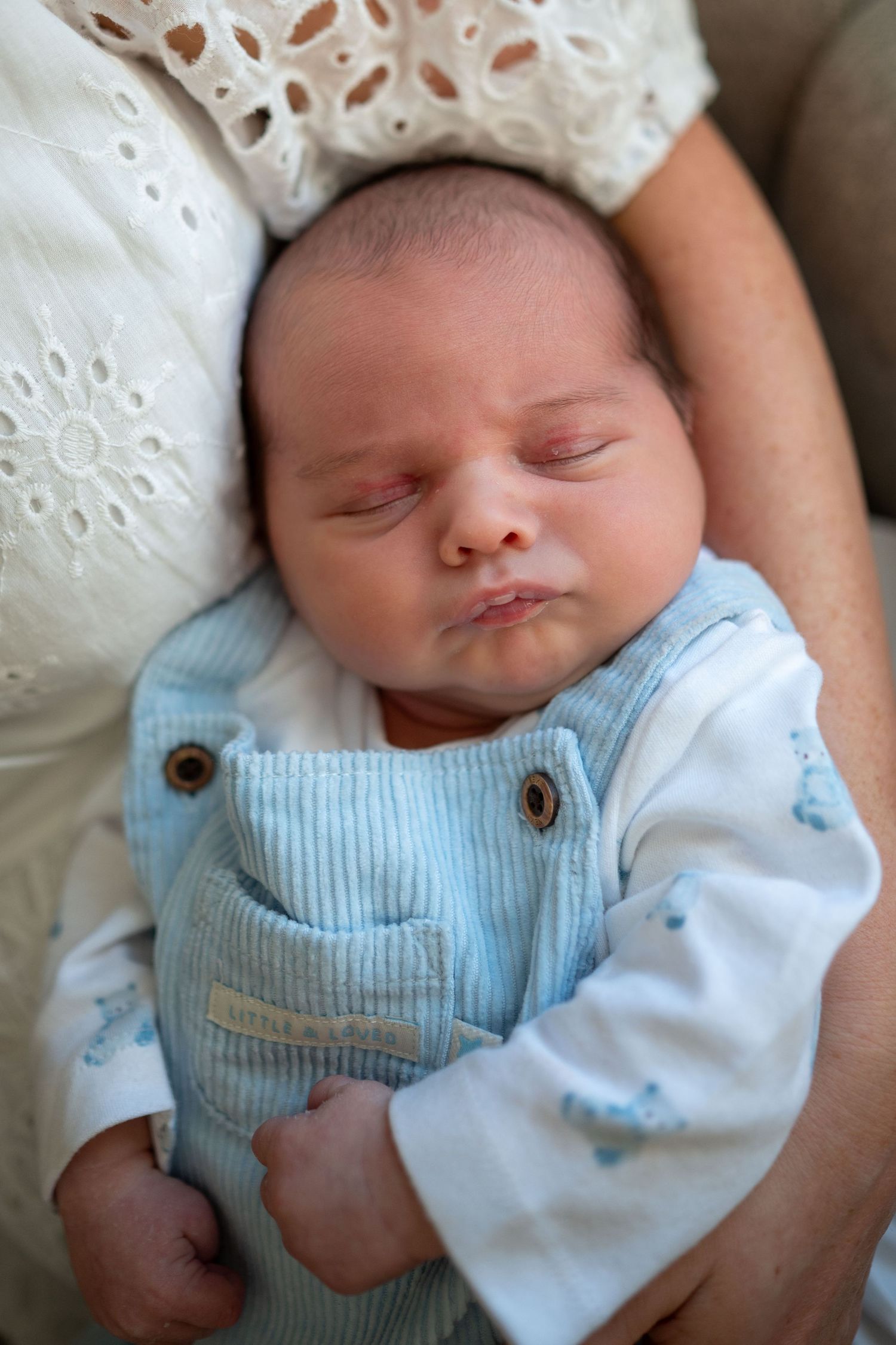 newborn baby waterford pouting blue suit asleep in mothers arms