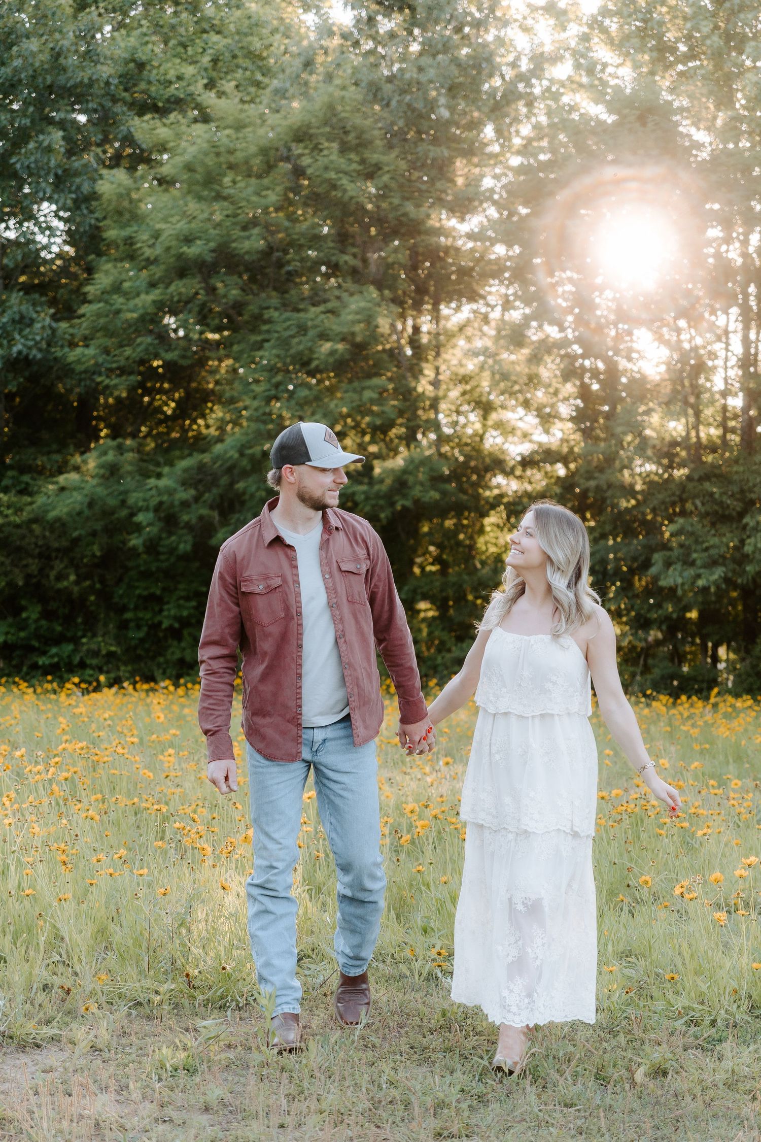 Couple walking in sunlit flower field