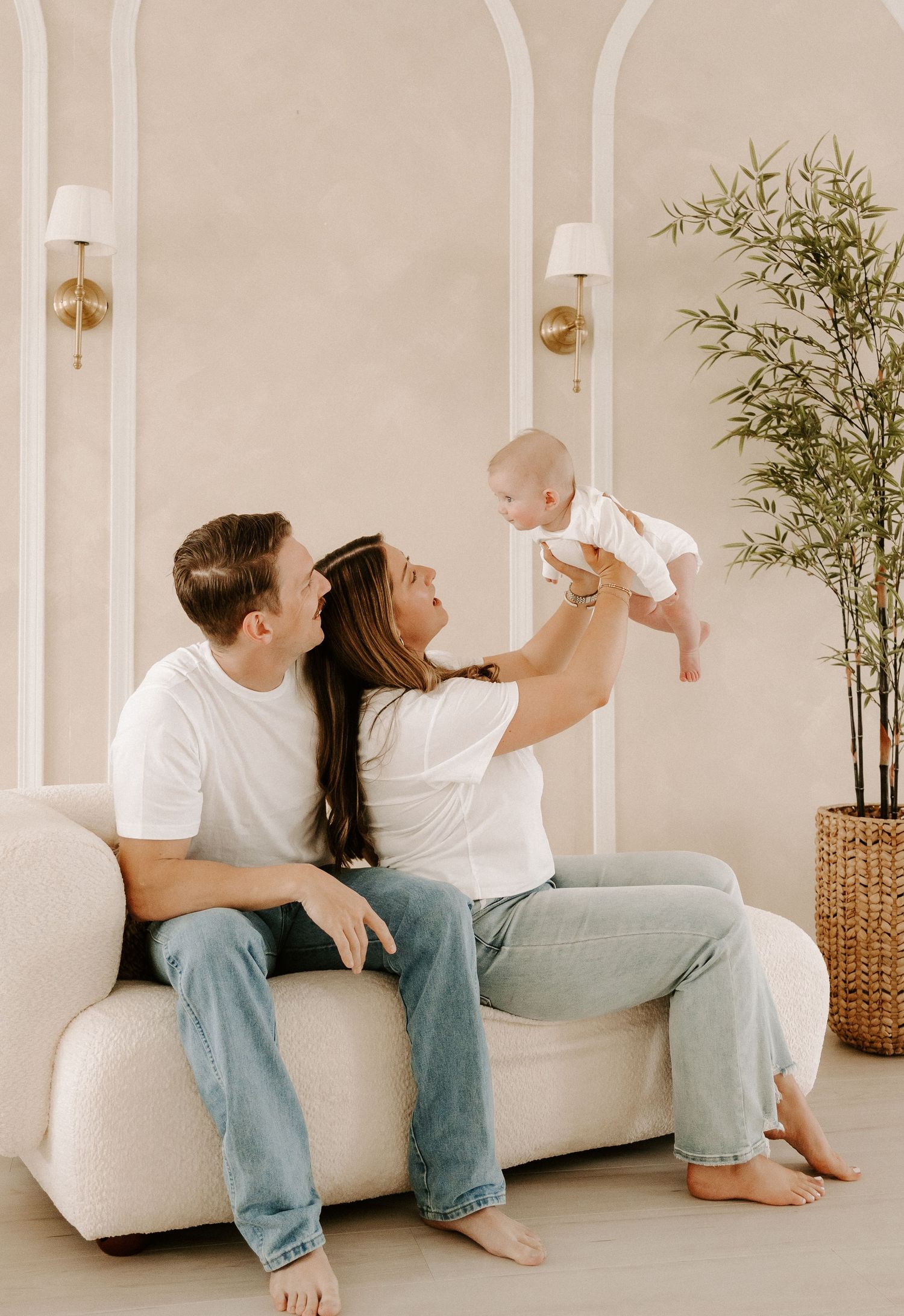 Dad and mom smiling and talking to baby