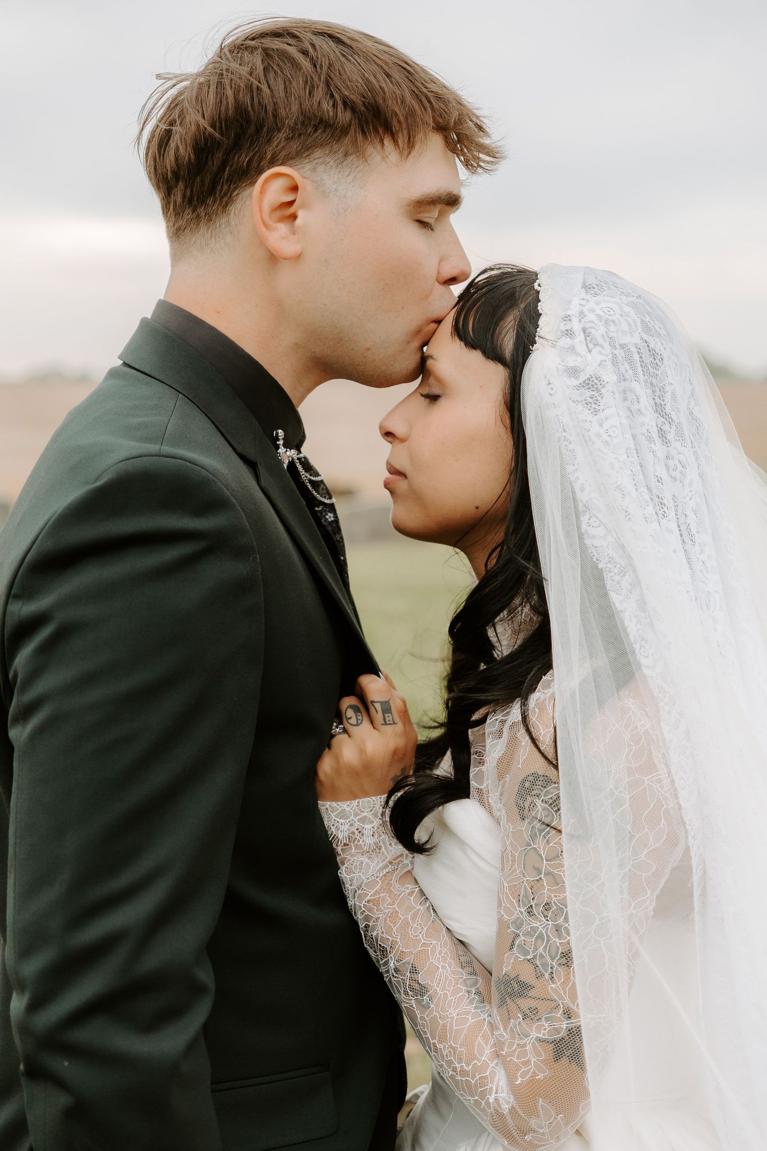 Groom kissing brides forehead