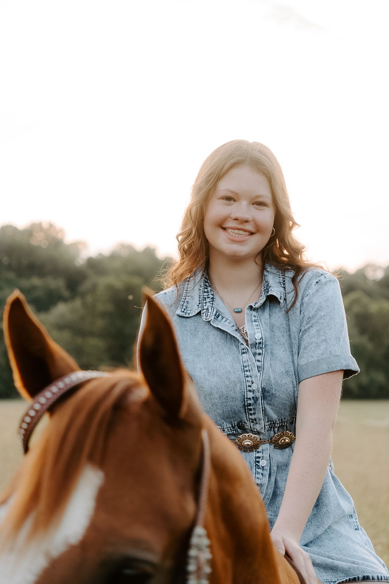Girl smiling at camera while riding her horse
