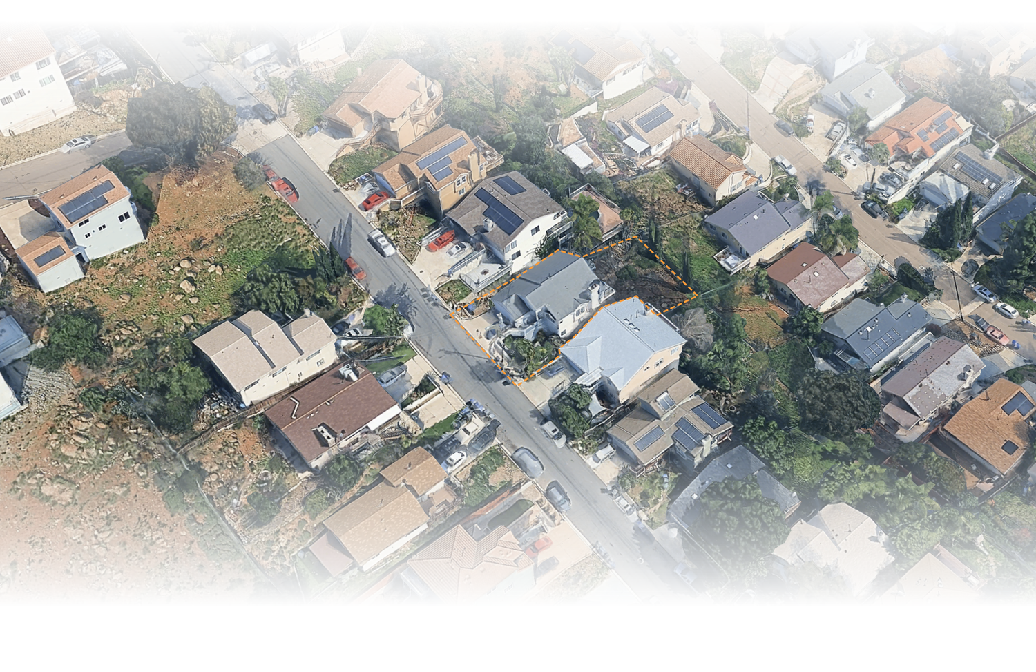 Aerial view of a dense residential neighborhood with houses, trees, and intersecting streets in a suburban area.