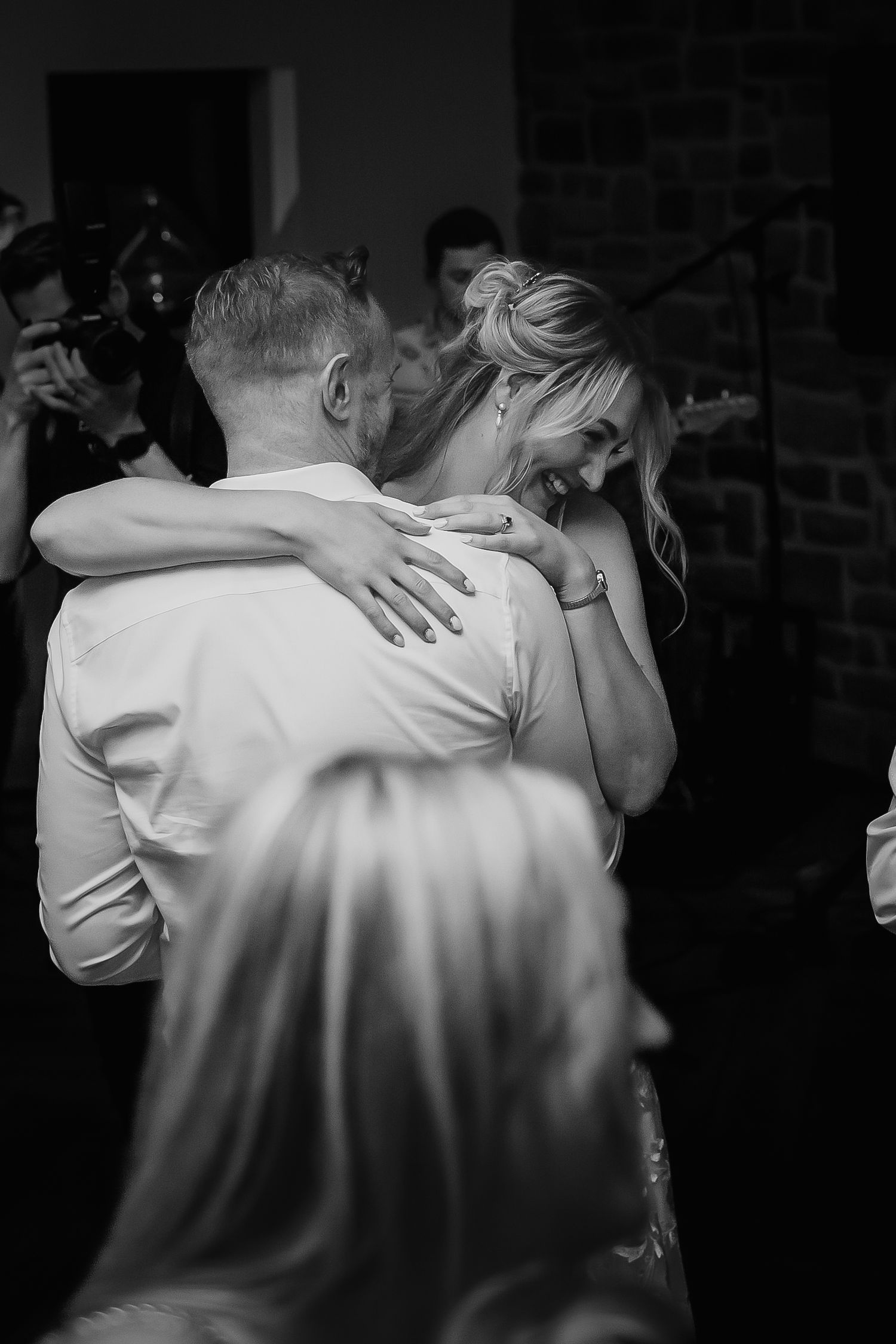 Black and white photo of bride and groom sharing emotional first dance at wedding reception.