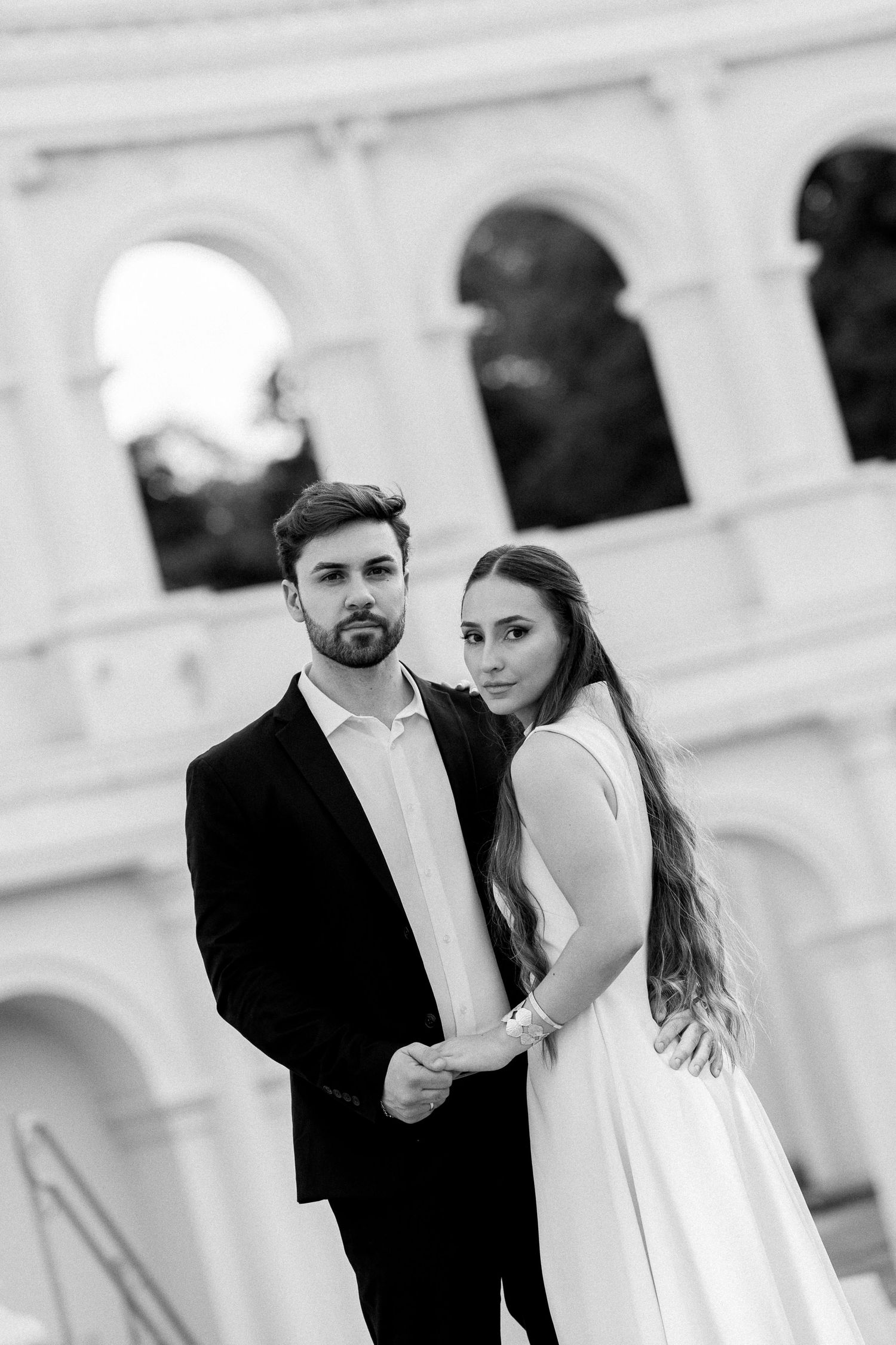 Black and white wedding photo of elegant couple posing in front of the Colosseum in Rome, Italy.