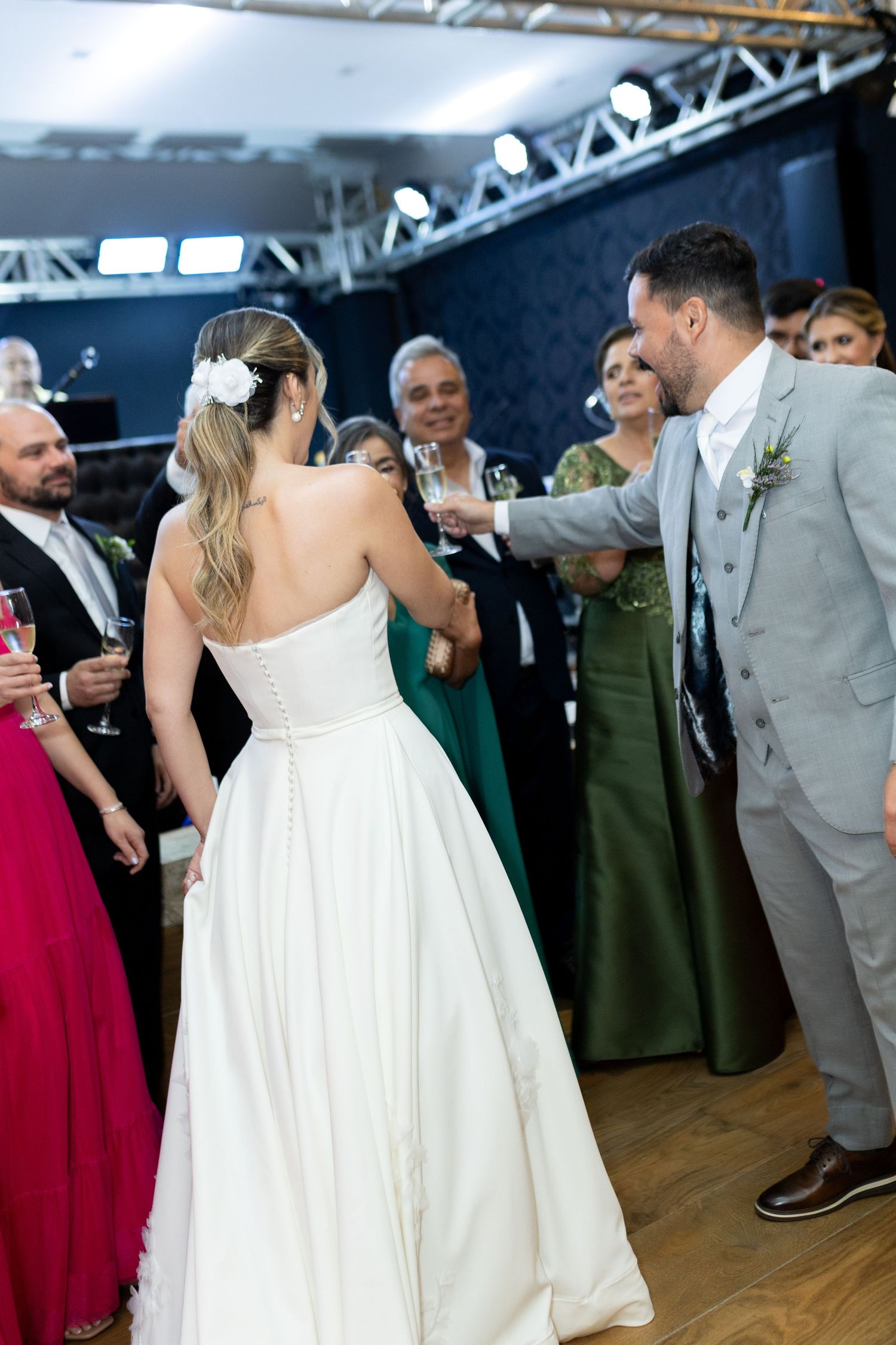 Bride and groom share first dance at elegant wedding reception surrounded by guests in formal attire.