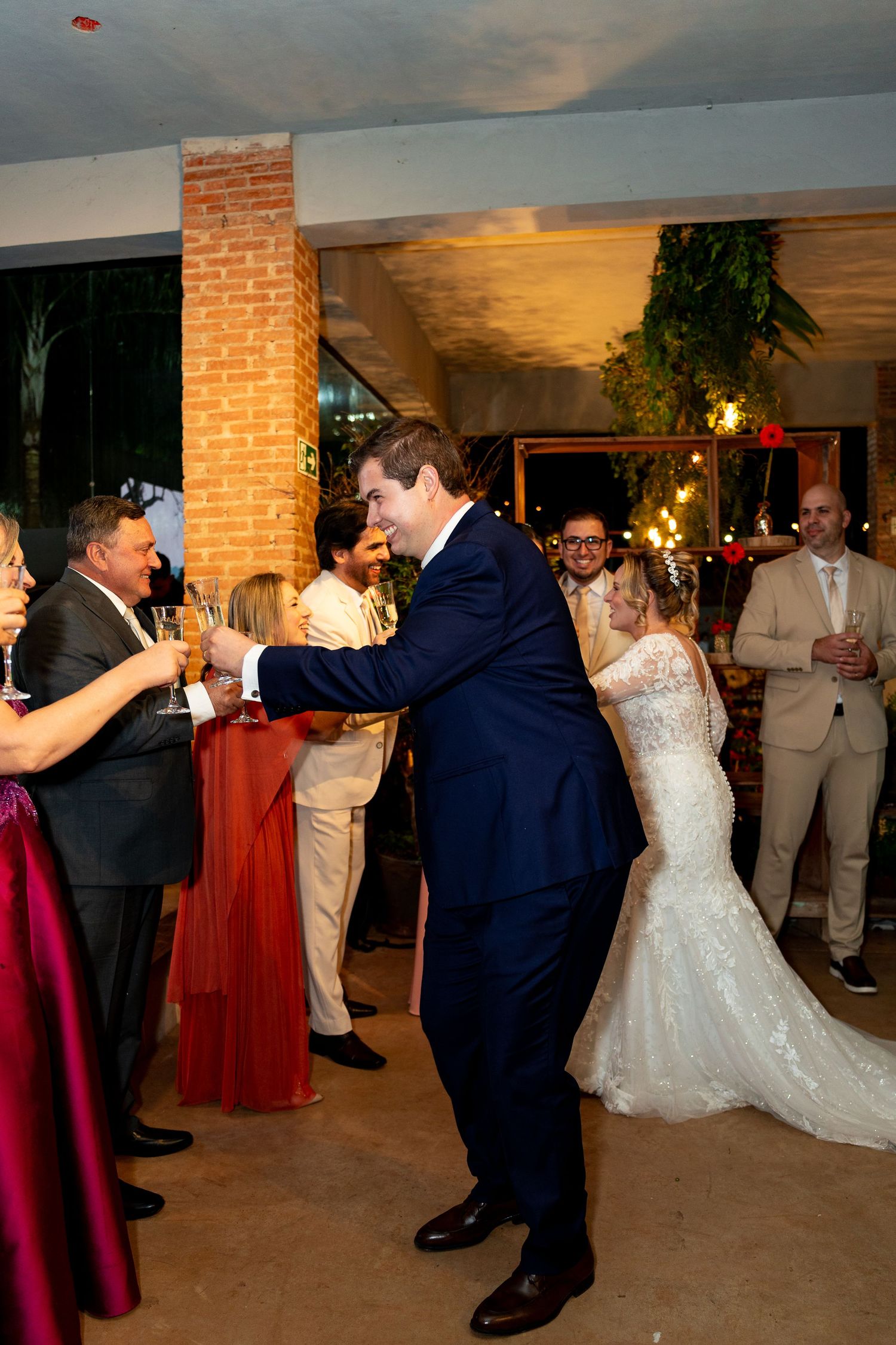 Bride and groom share a joyful first dance at their wedding reception surrounded by guests in elegant attire.