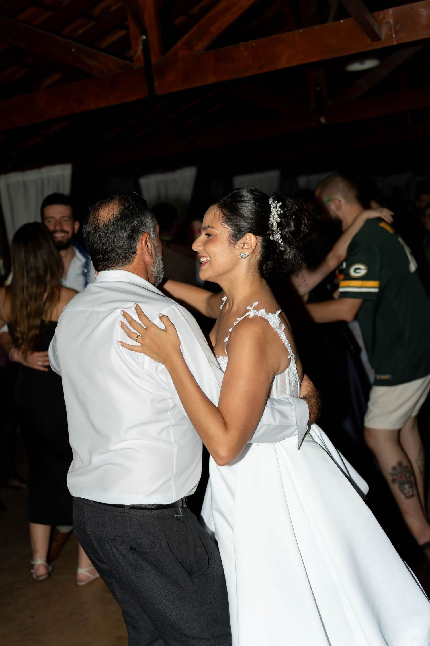Bride in white gown shares a joyful first dance with partner at elegant indoor wedding reception.
