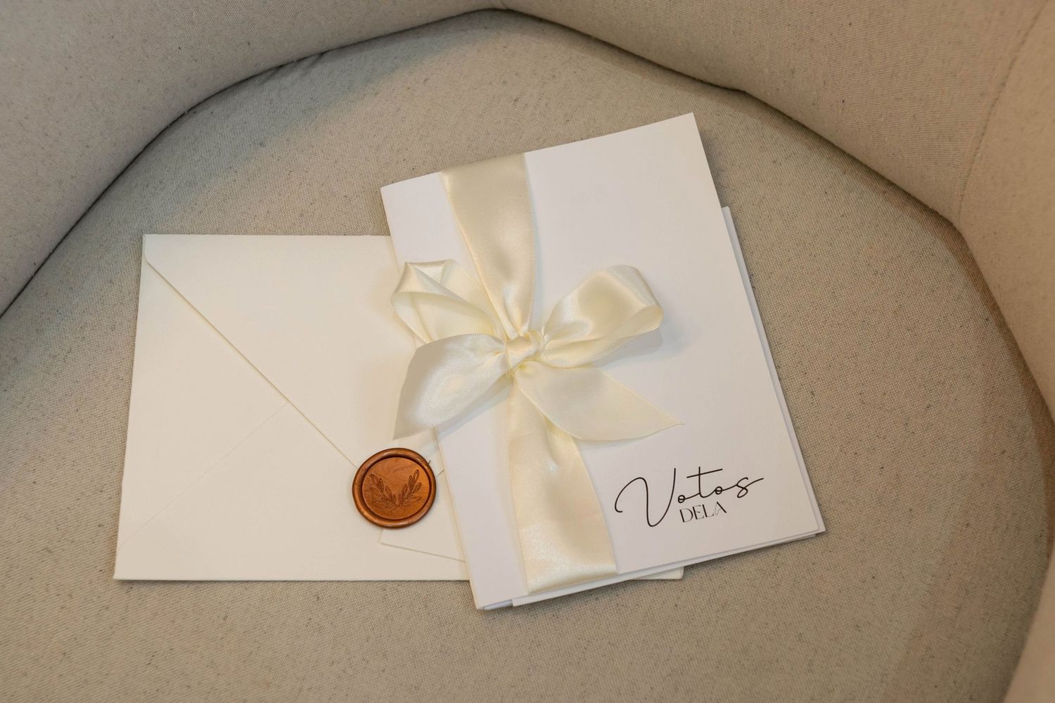 Elegant wedding stationery with ivory envelope, wax seal, ribbon-tied card, and Vito branding on neutral background.