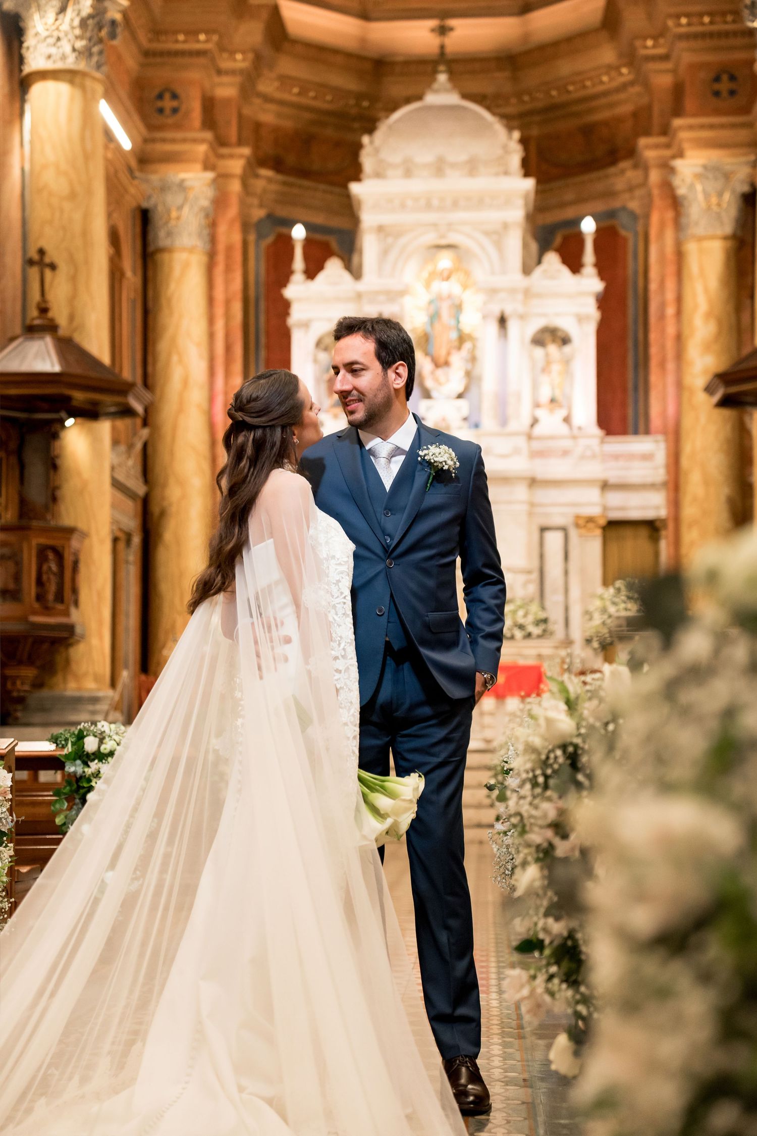 Bride and groom share a romantic moment at the church altar during their elegant wedding ceremony.