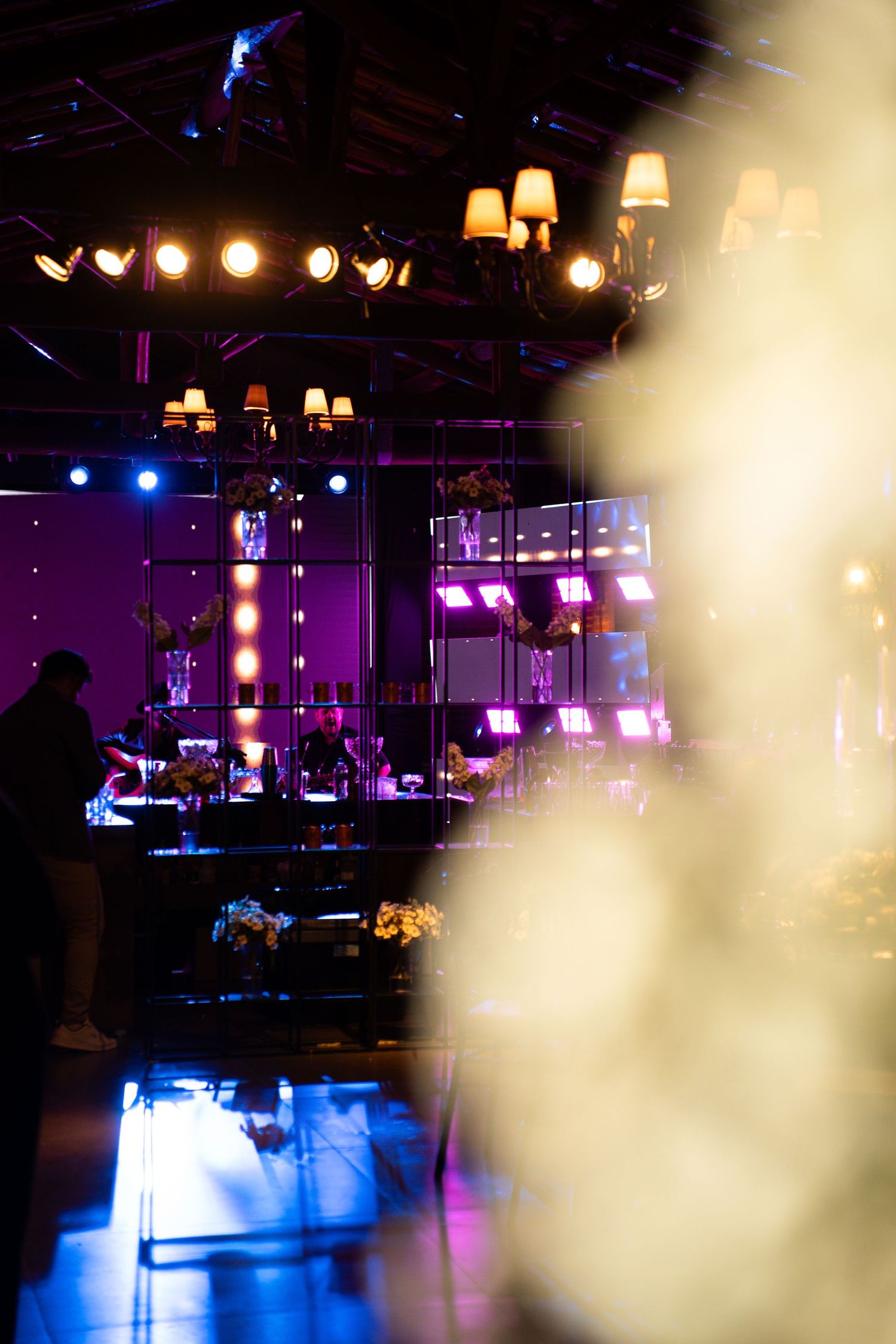 Elegant event venue with purple lighting, stage lights, and decorative lamps creating a vibrant atmosphere.