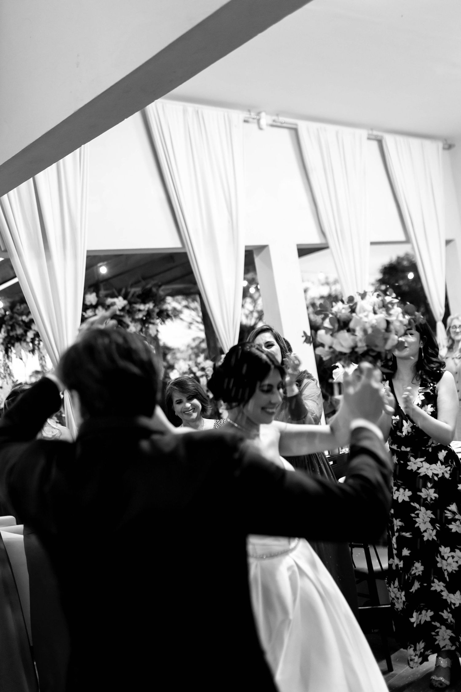 Black and white photo of a bride and groom sharing their first dance at an elegant wedding reception.