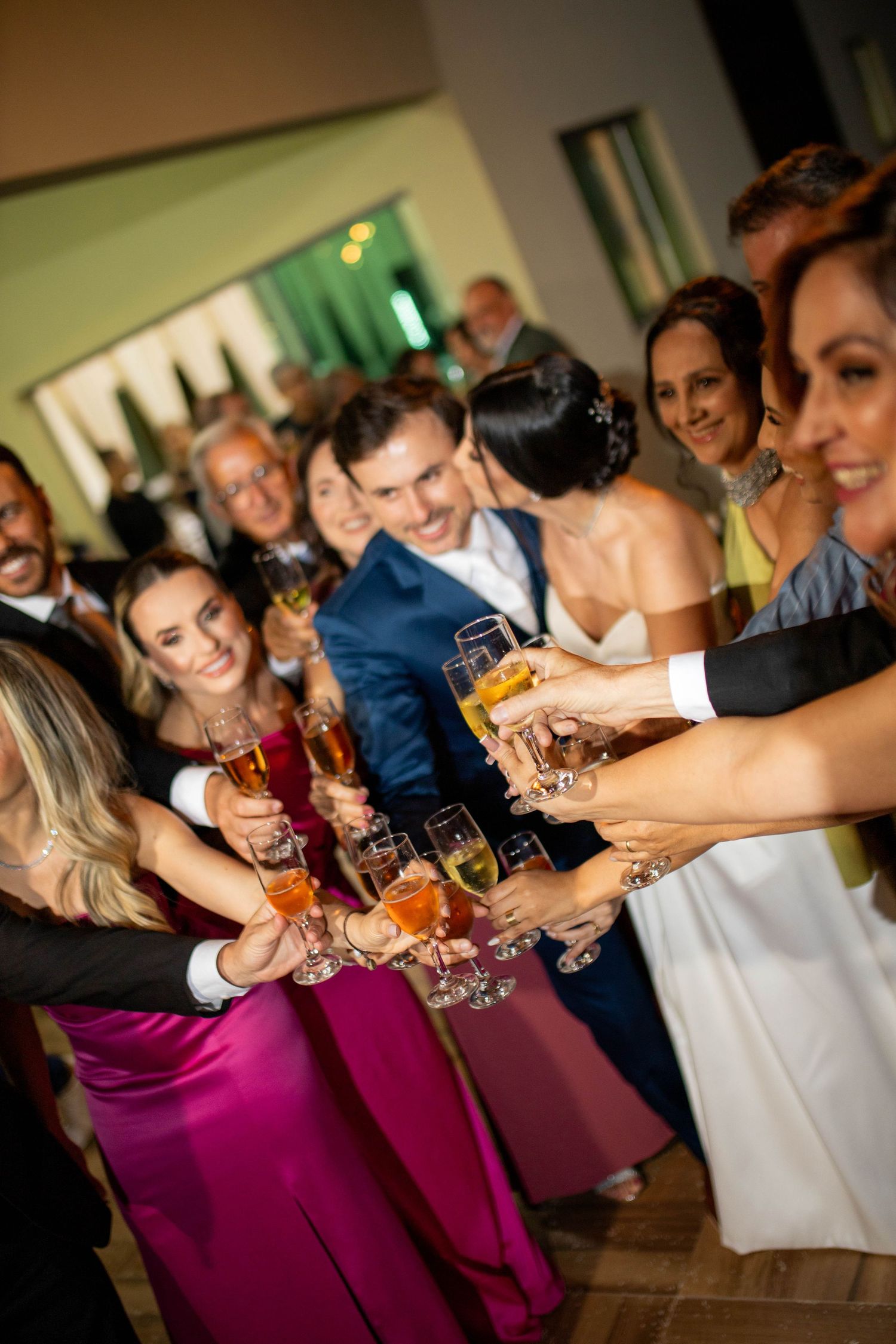Wedding guests raising champagne glasses in a joyful toast celebration at an elegant reception.