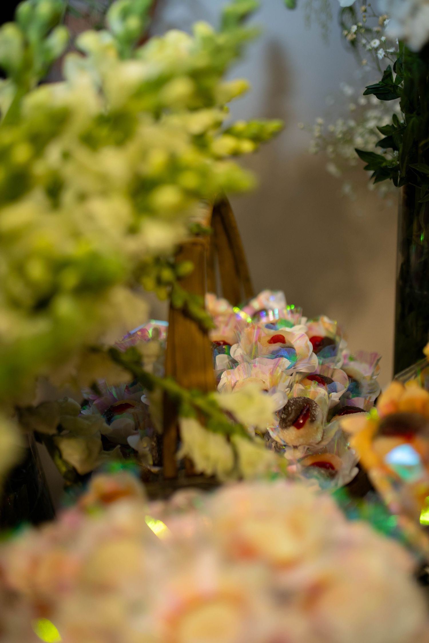 Close-up of colorful decorative flowers and green floral arrangements at an elegant event display.