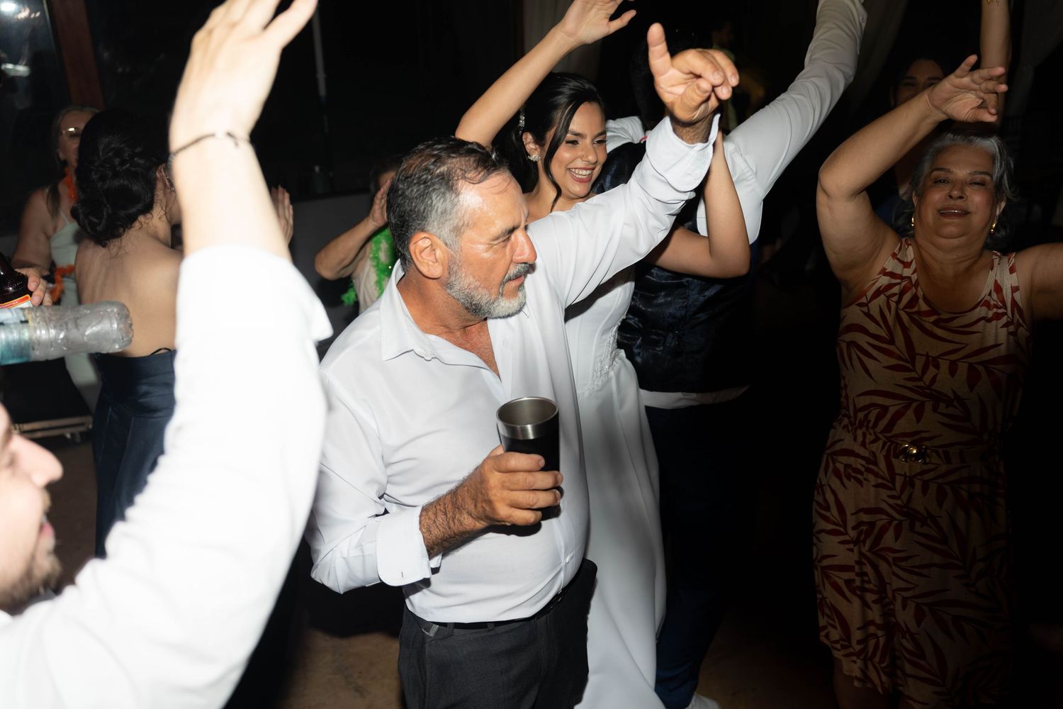 People dancing joyfully at an outdoor evening party celebration.