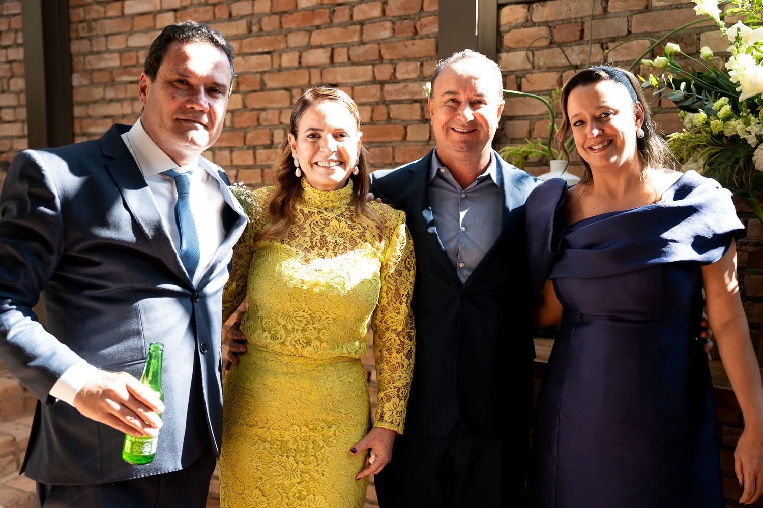 Four elegantly dressed people posing together at a formal event, wearing blue and gold outfits.