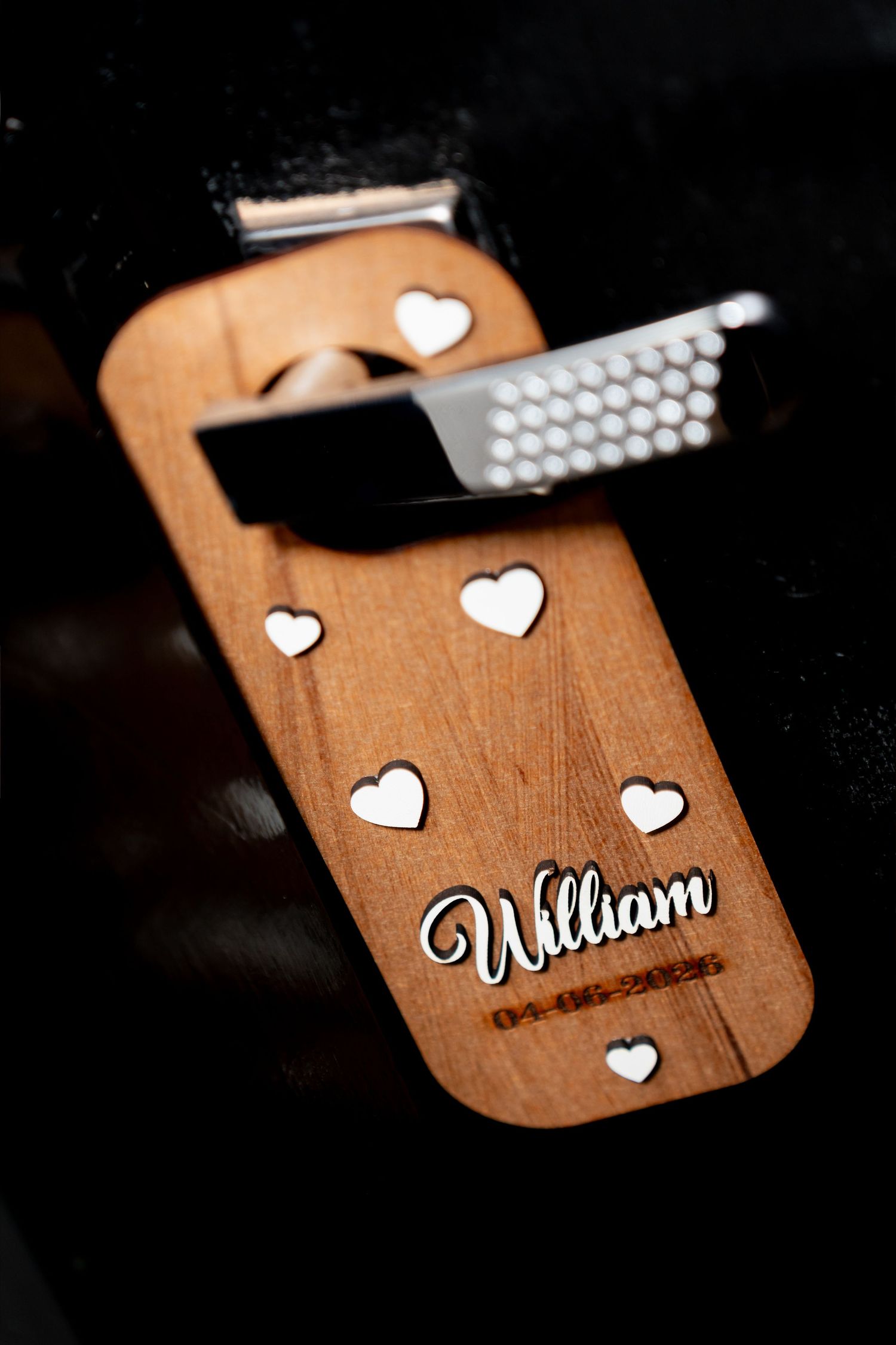 Personalized wooden bottle opener with heart cutouts and the name William engraved, a unique wedding or party favor gift.