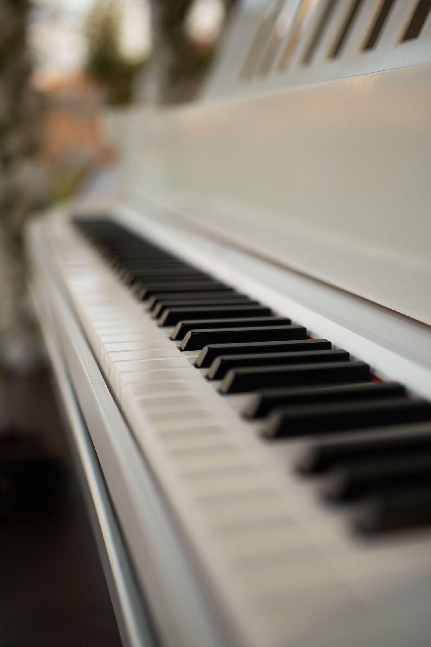 Close-up of white piano keys with black keys in shallow depth of field, elegant musical instrument photography.