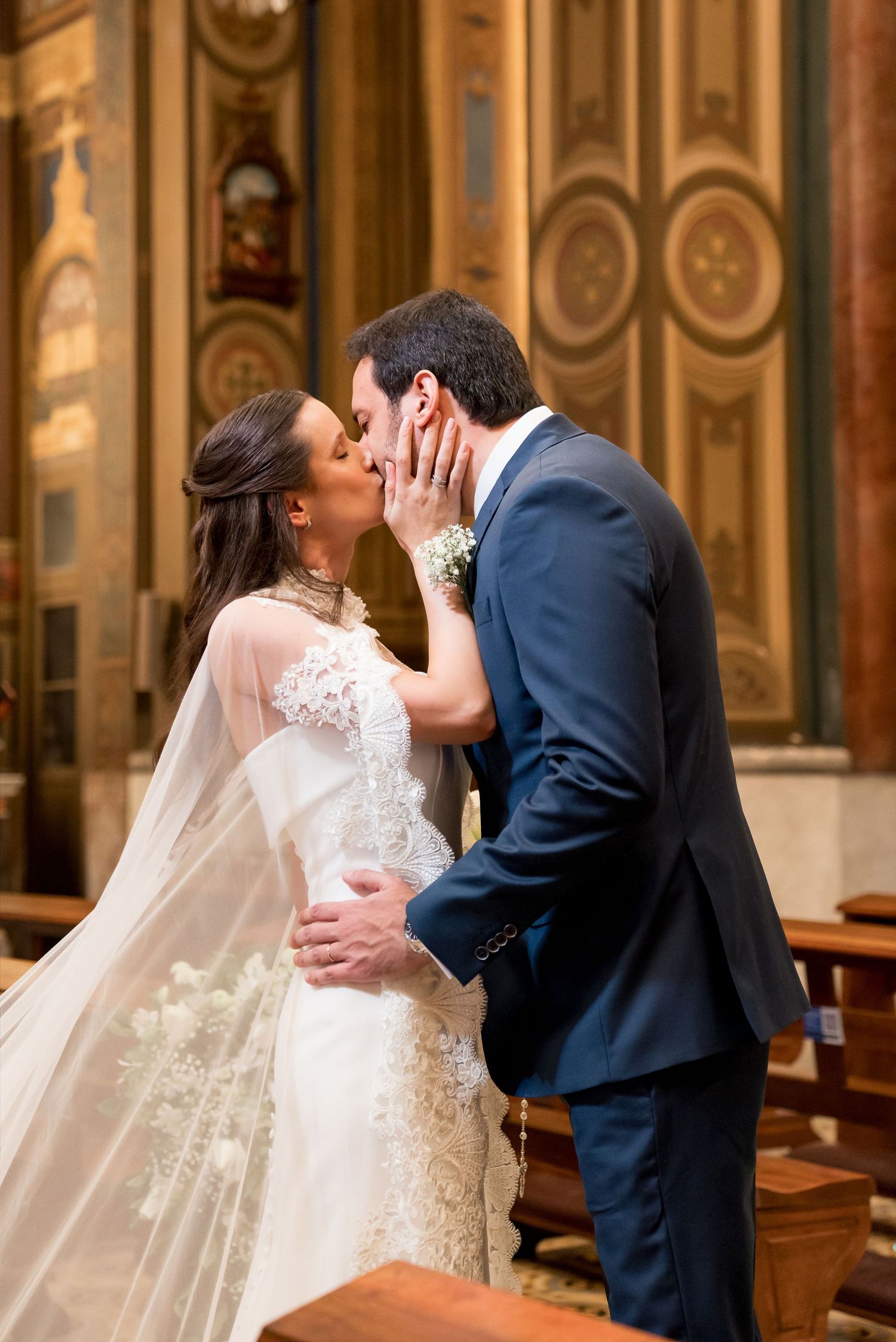 Bride and groom share their first kiss at the altar in a stunning church wedding ceremony.