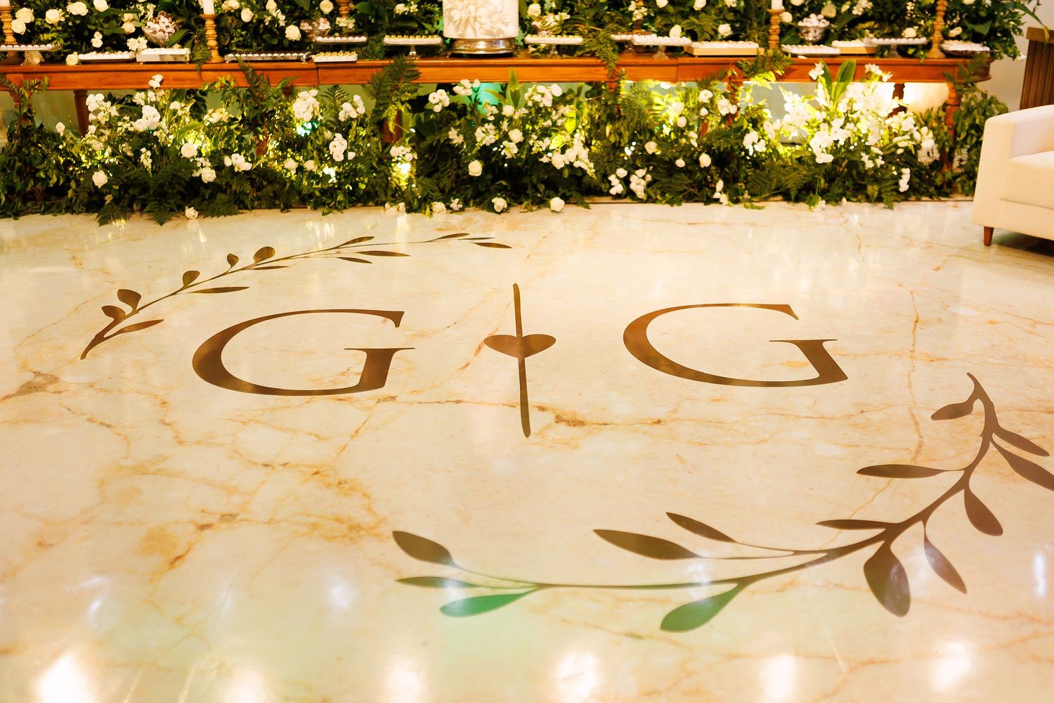 Elegant marble dance floor with G&G monogram and olive branch design at a wedding reception.