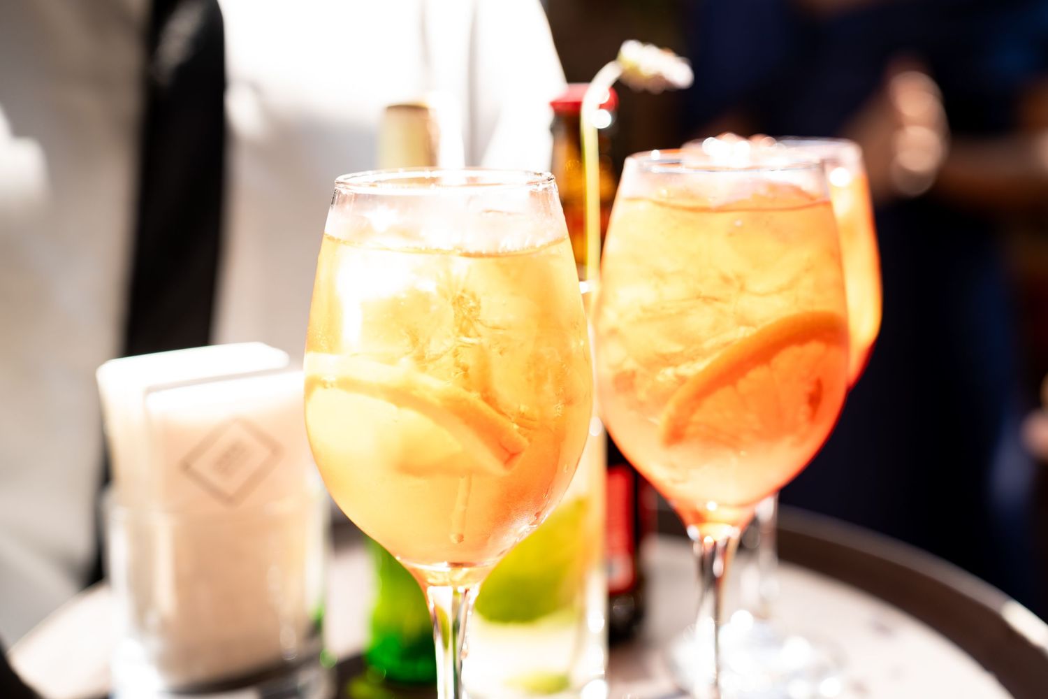 Two elegant wine glasses filled with refreshing citrus spritz cocktails garnished with grapefruit slices and ice.