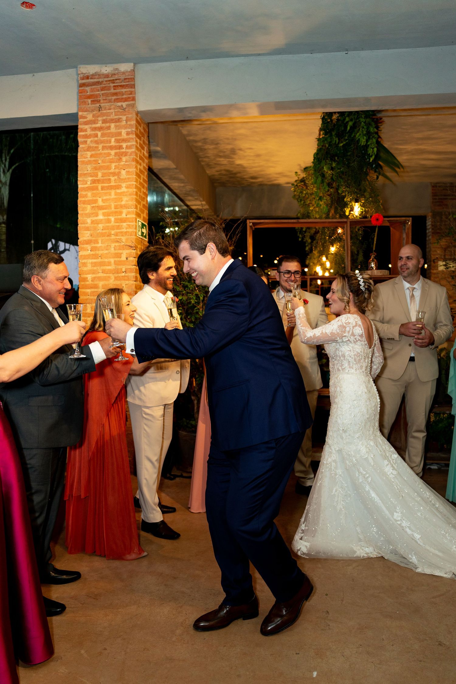 Bride and groom share first dance at wedding reception, surrounded by guests celebrating in elegant venue.