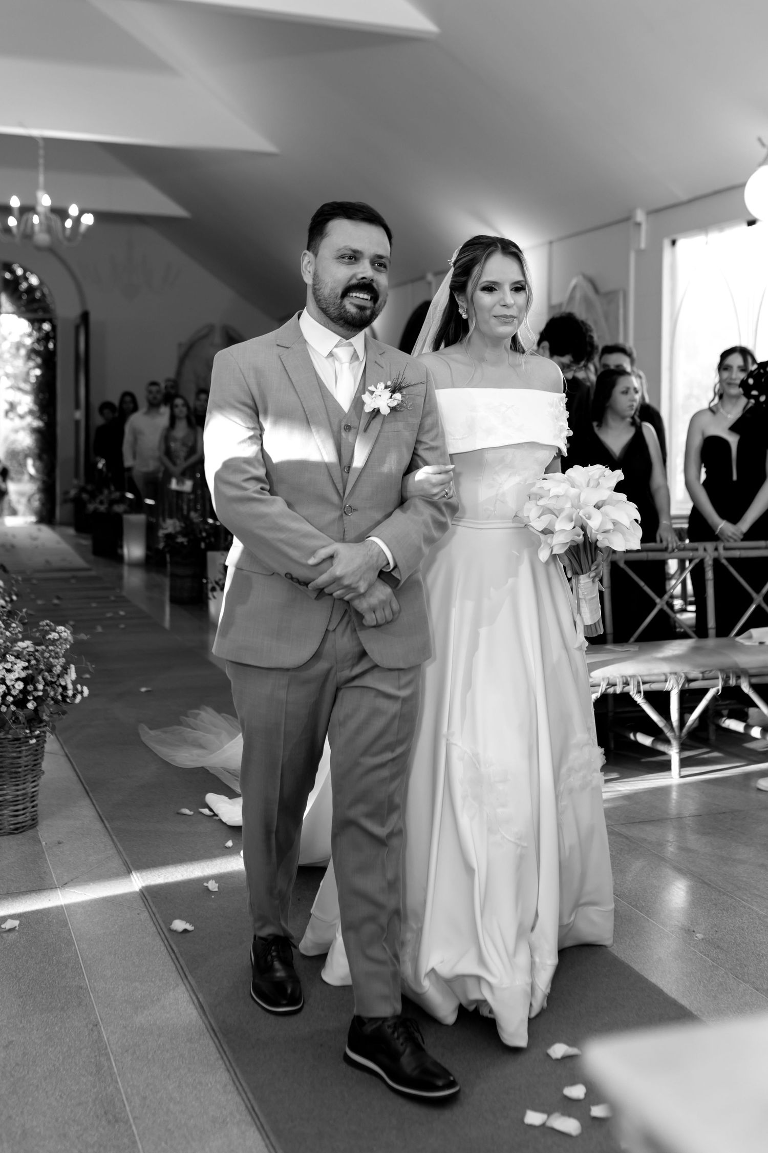 Black and white photo of a bride and groom walking down the aisle at their wedding ceremony.