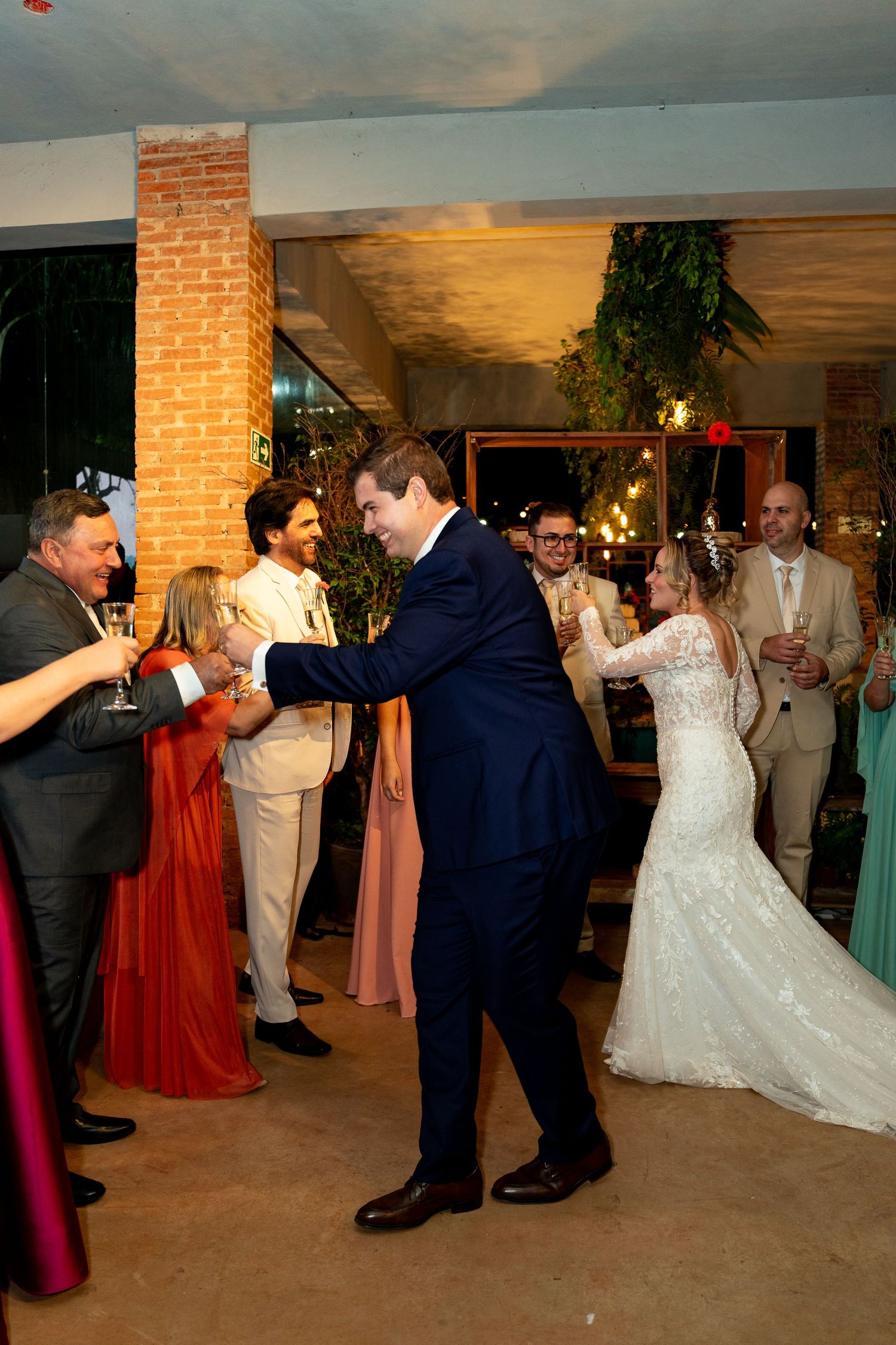 Bride and groom share first dance at elegant wedding reception surrounded by guests in formal attire.
