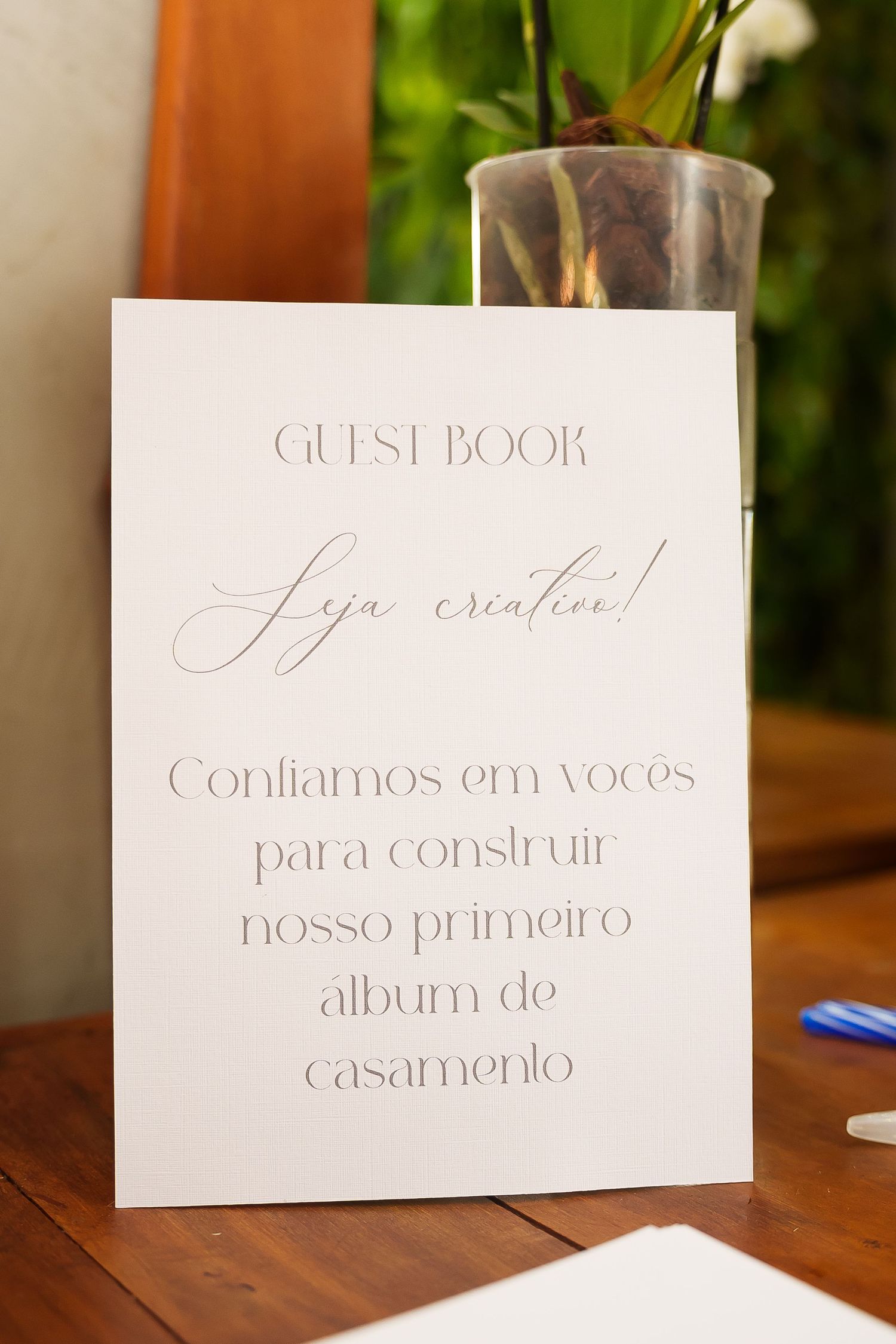 Portuguese wedding guest book sign on wooden table reading 