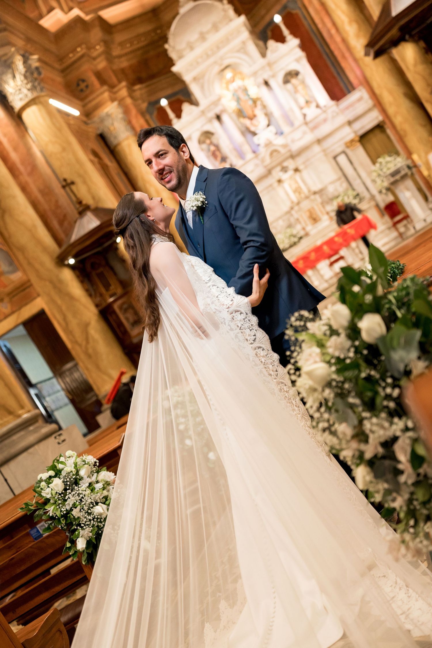 A joyful bride and groom share a romantic moment at the church altar during their wedding ceremony.