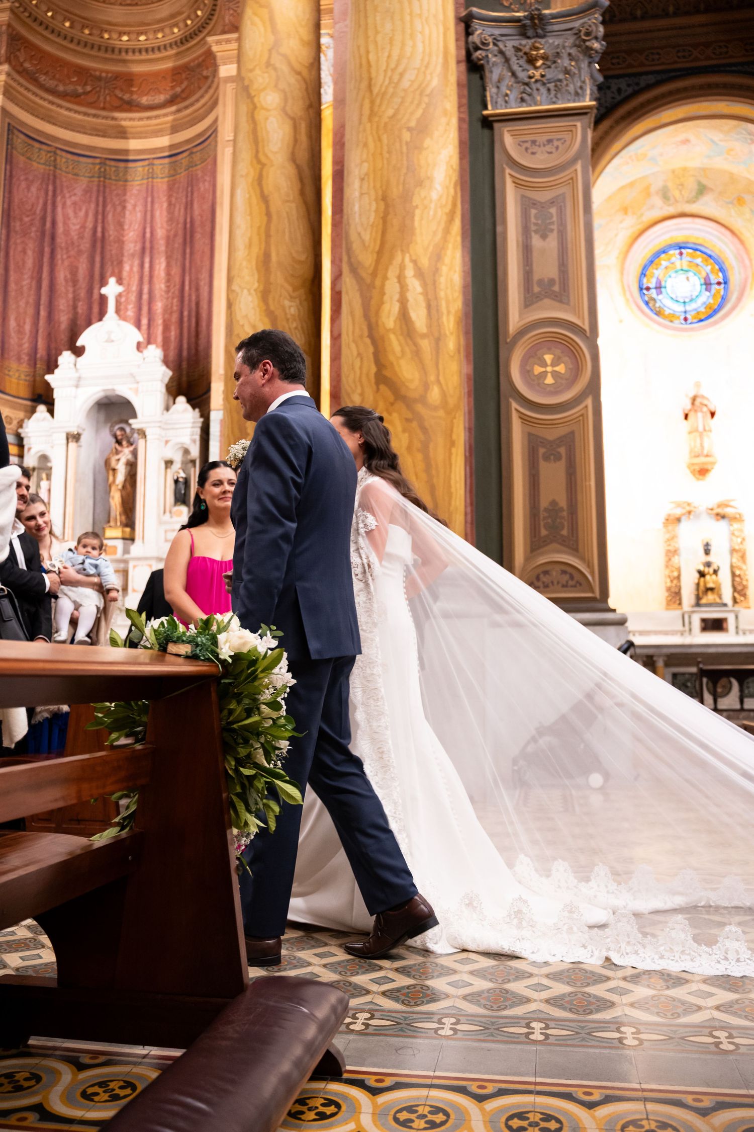 Bride and groom walking down the aisle in an ornate church during their wedding ceremony.