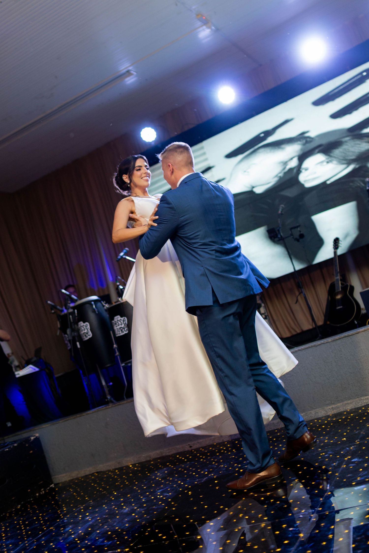 Bride and groom share their first dance at wedding reception with live band and starlit dance floor.