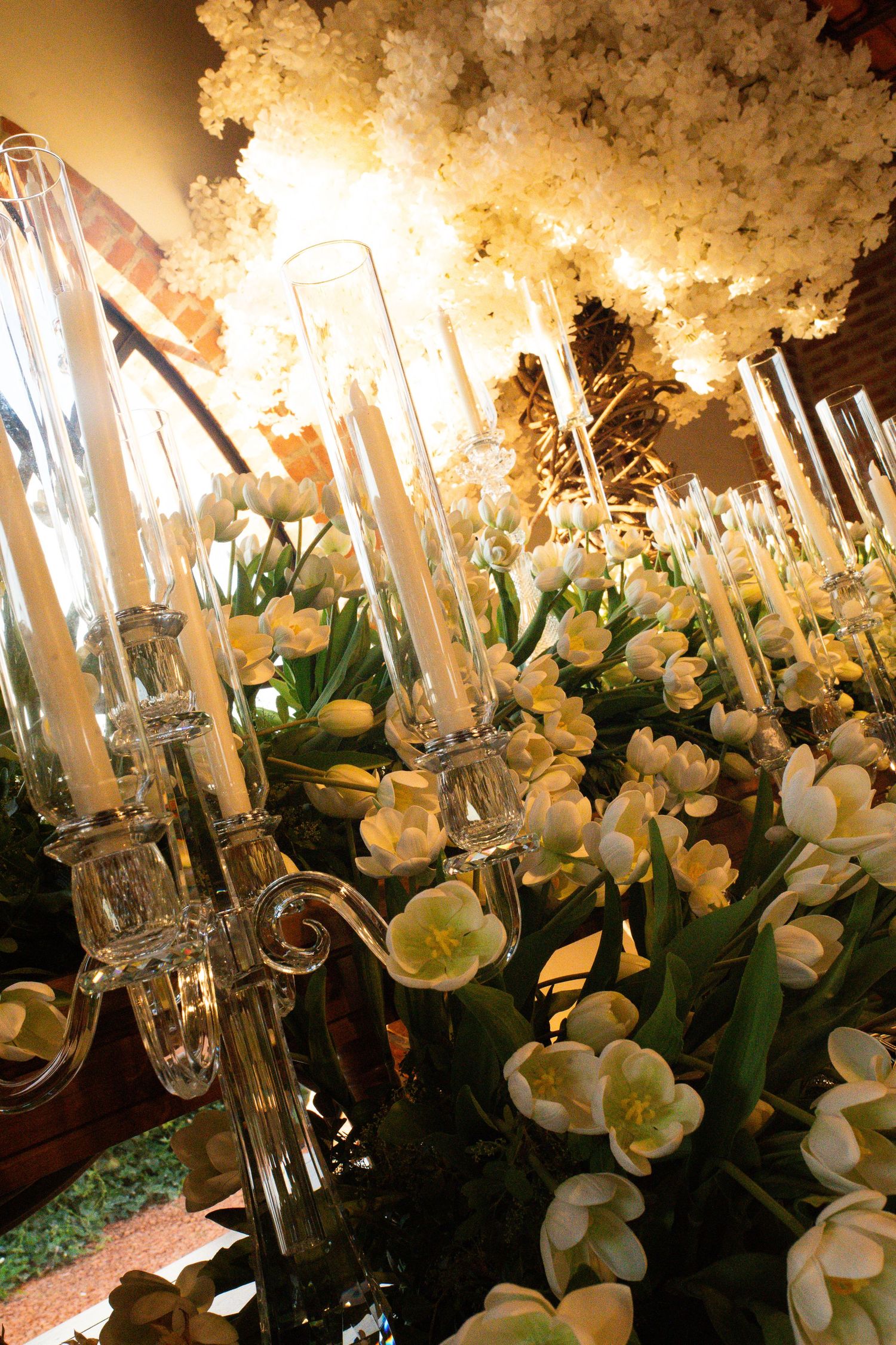 Elegant wedding centerpiece with crystal candelabras, white tulips, and glowing floral arrangements creating a romantic ambiance.