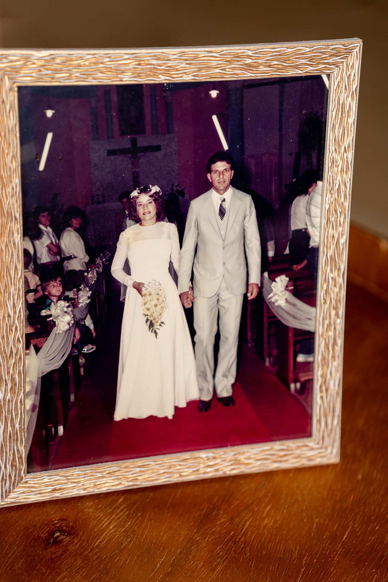 Framed vintage wedding photo of a couple walking down a church aisle.