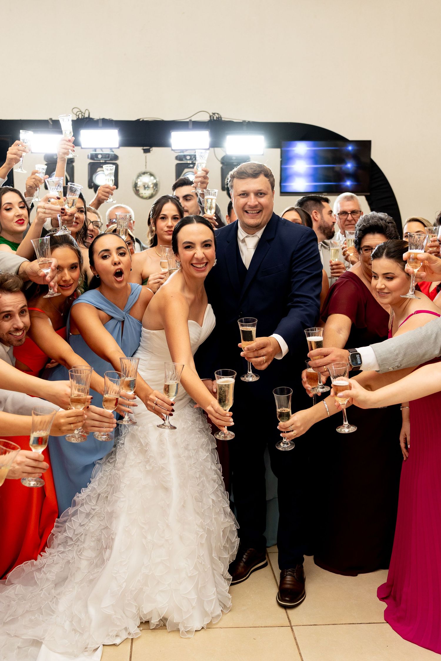 Bride and groom toasting champagne with wedding guests at a festive reception celebration.