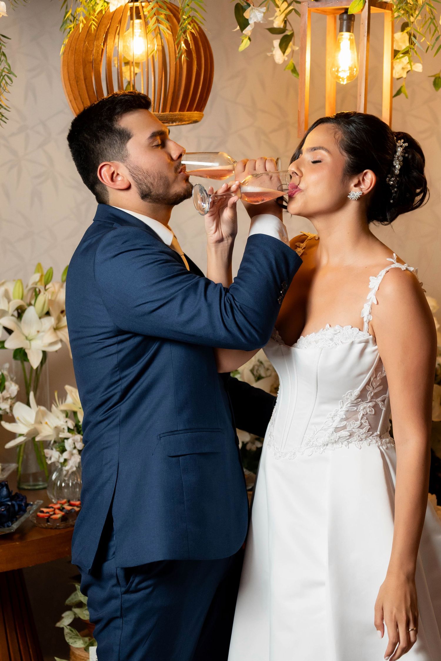 Bride and groom drinking champagne together at their wedding reception indoors.