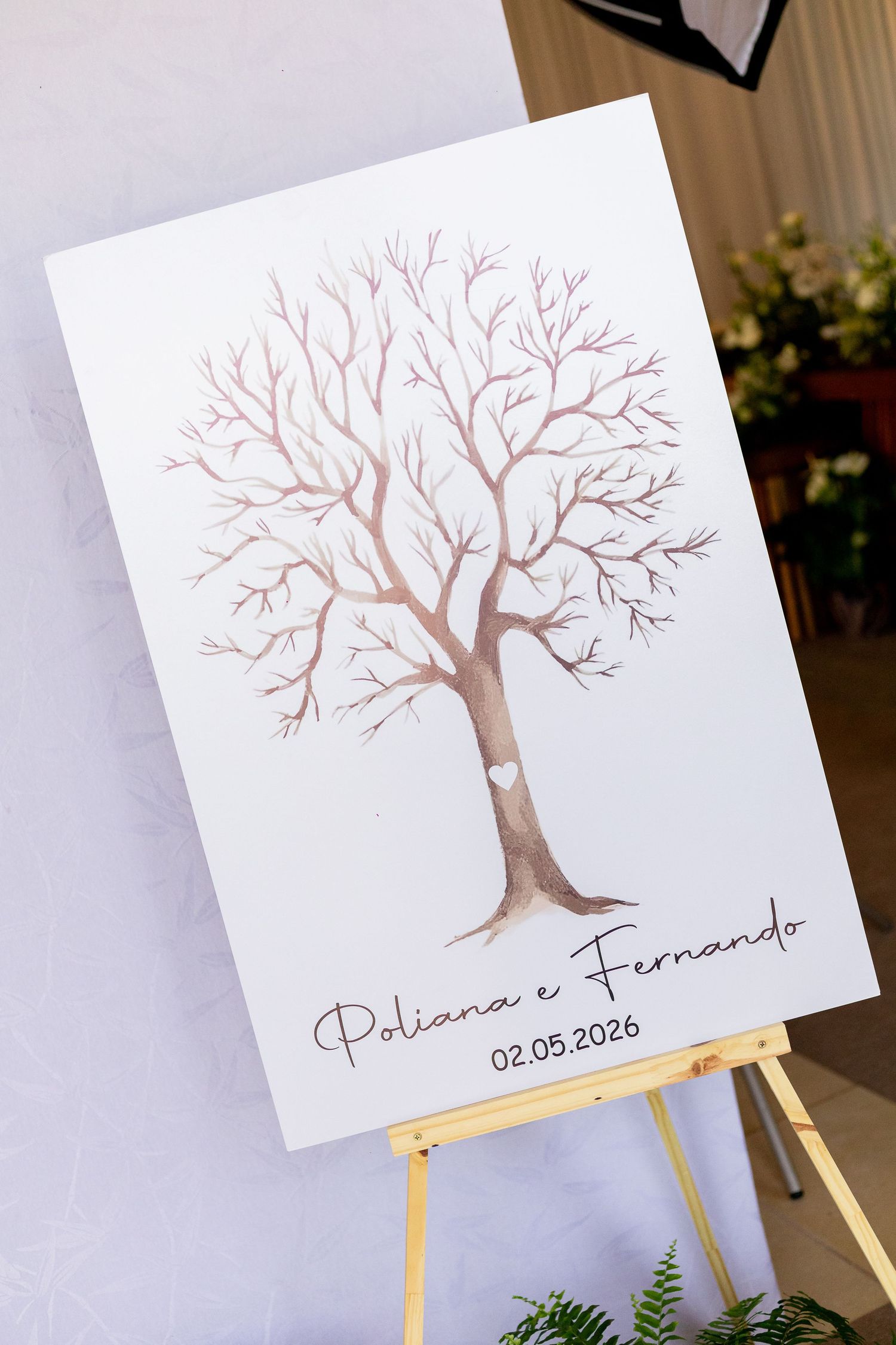 Wedding fingerprint tree canvas sign for Poliana e Fernando dated 02.05.2026 displayed on a wooden easel.