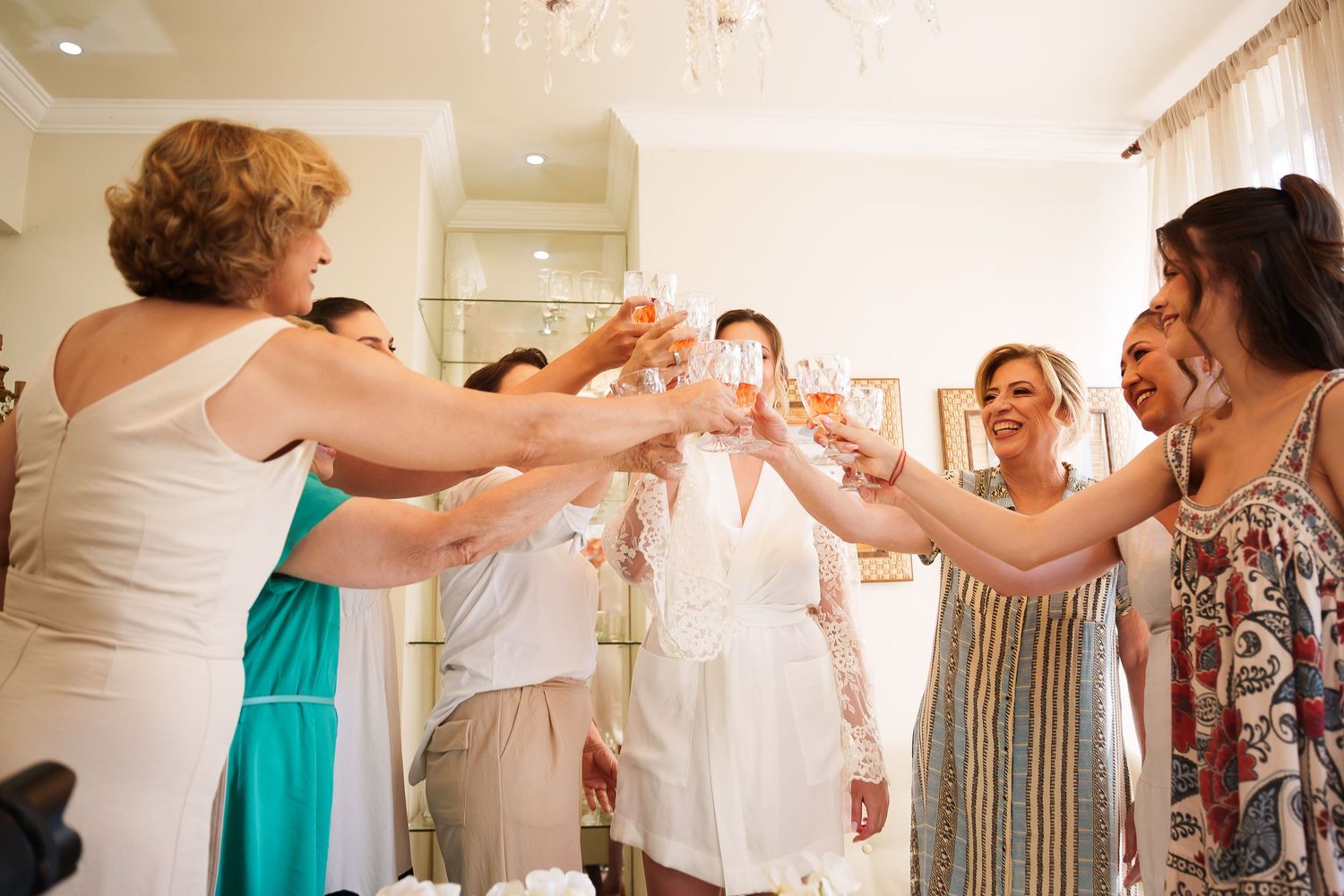 Women toasting with champagne glasses at a bridal shower celebration indoors.