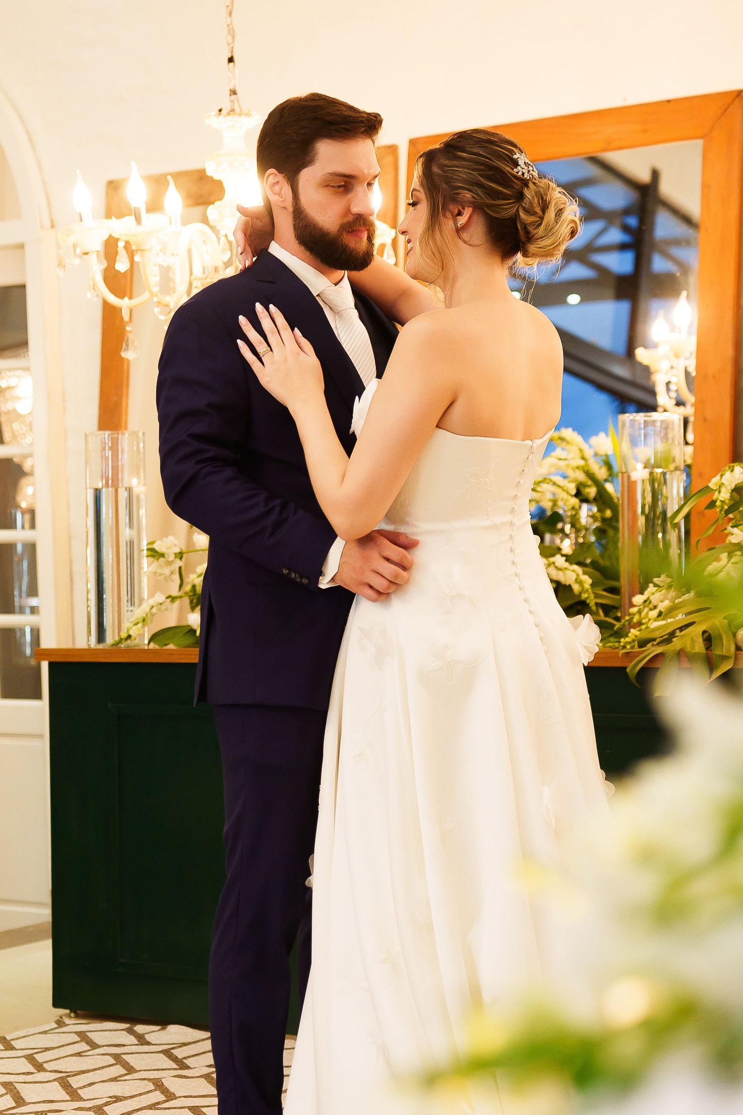 Bride and groom share a romantic dance at their wedding reception, with the bride in a white strapless gown.