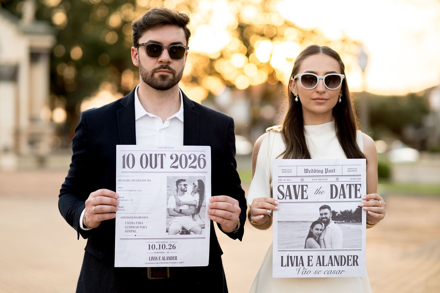 Elegant couple in sunglasses holding Save the Date wedding cards dated 10 OUT 2026 for Livia and Alander.