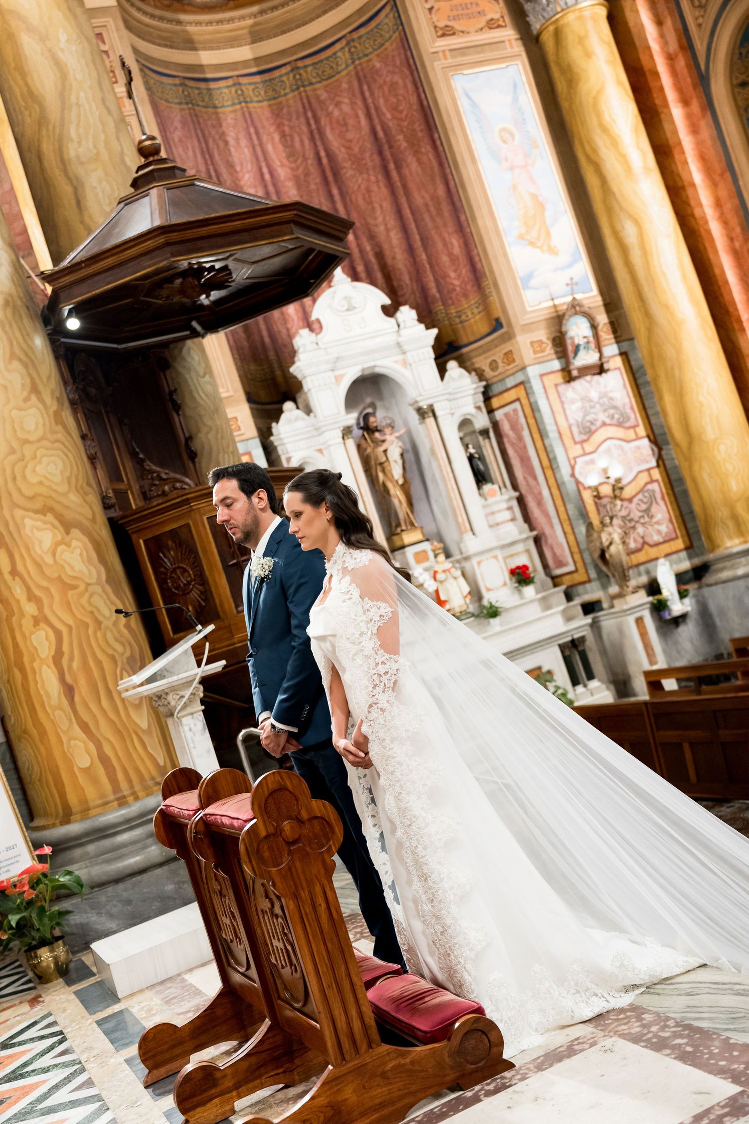 Bride and groom standing at the altar during a church wedding ceremony in an ornate Catholic cathedral.