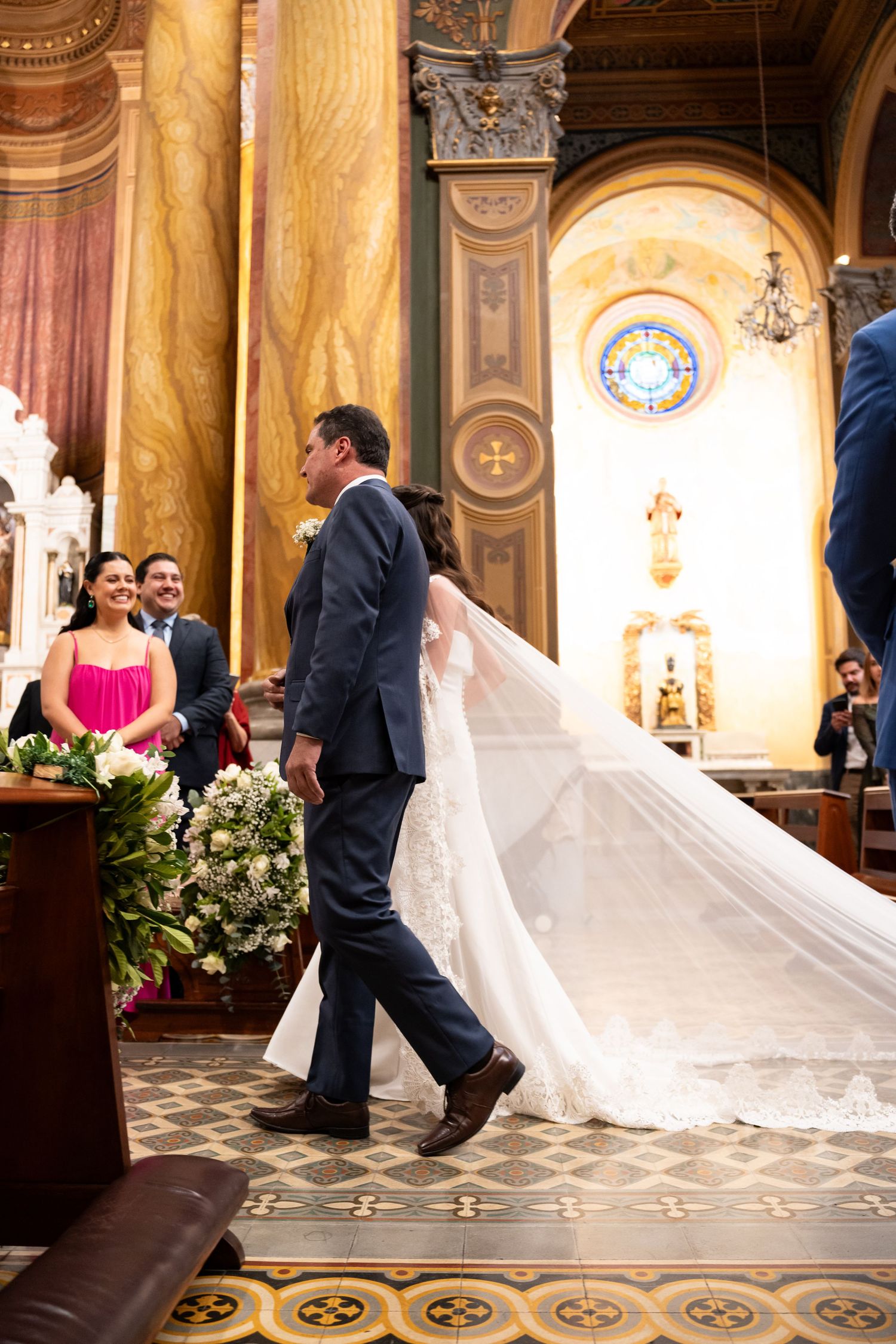 Bride and groom walking down the aisle in an ornate church during their wedding ceremony.