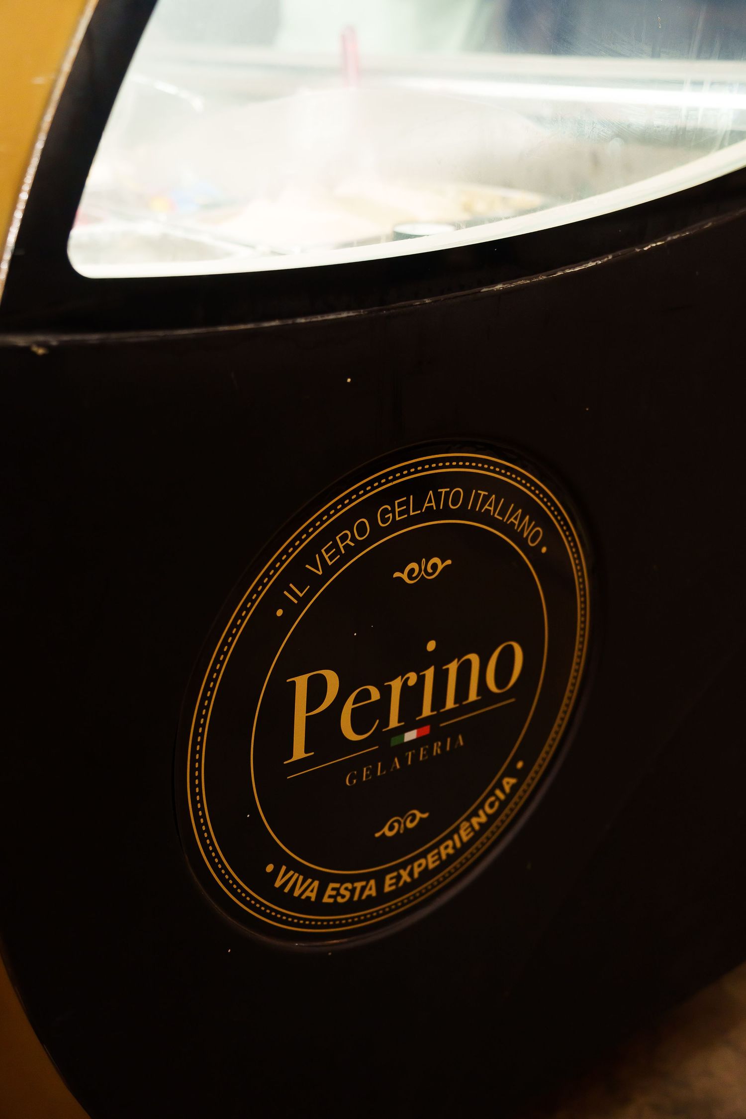 Perino Gelateria black freezer display with gold logo reading Il Vero Gelato Italiano and Viva Esta Experiencia.