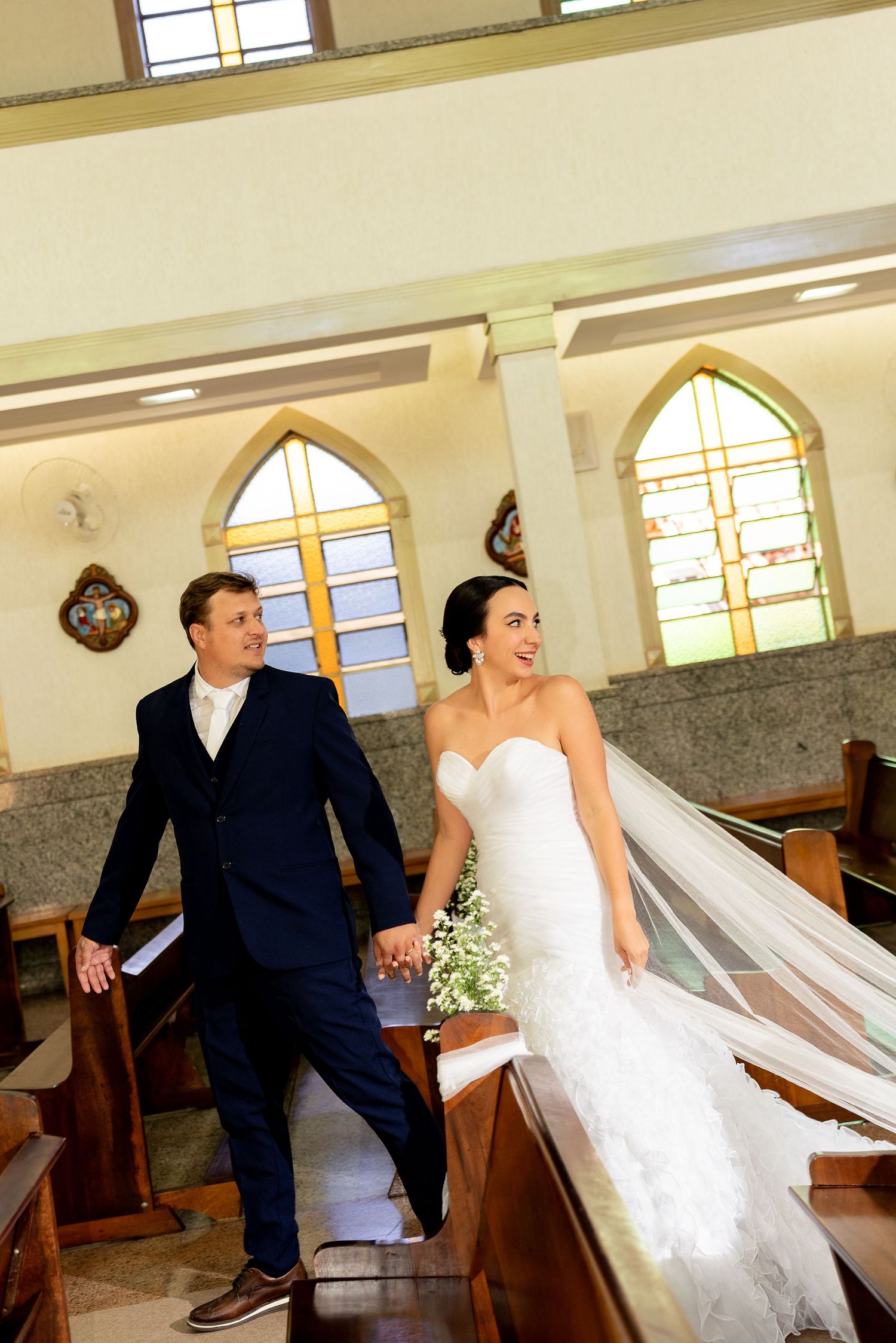 Bride and groom walking hand in hand down the aisle of a church after their wedding ceremony.