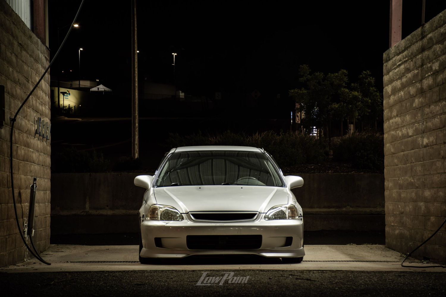 Silver Honda Civic photographed at self service car wash at night with moody lighting