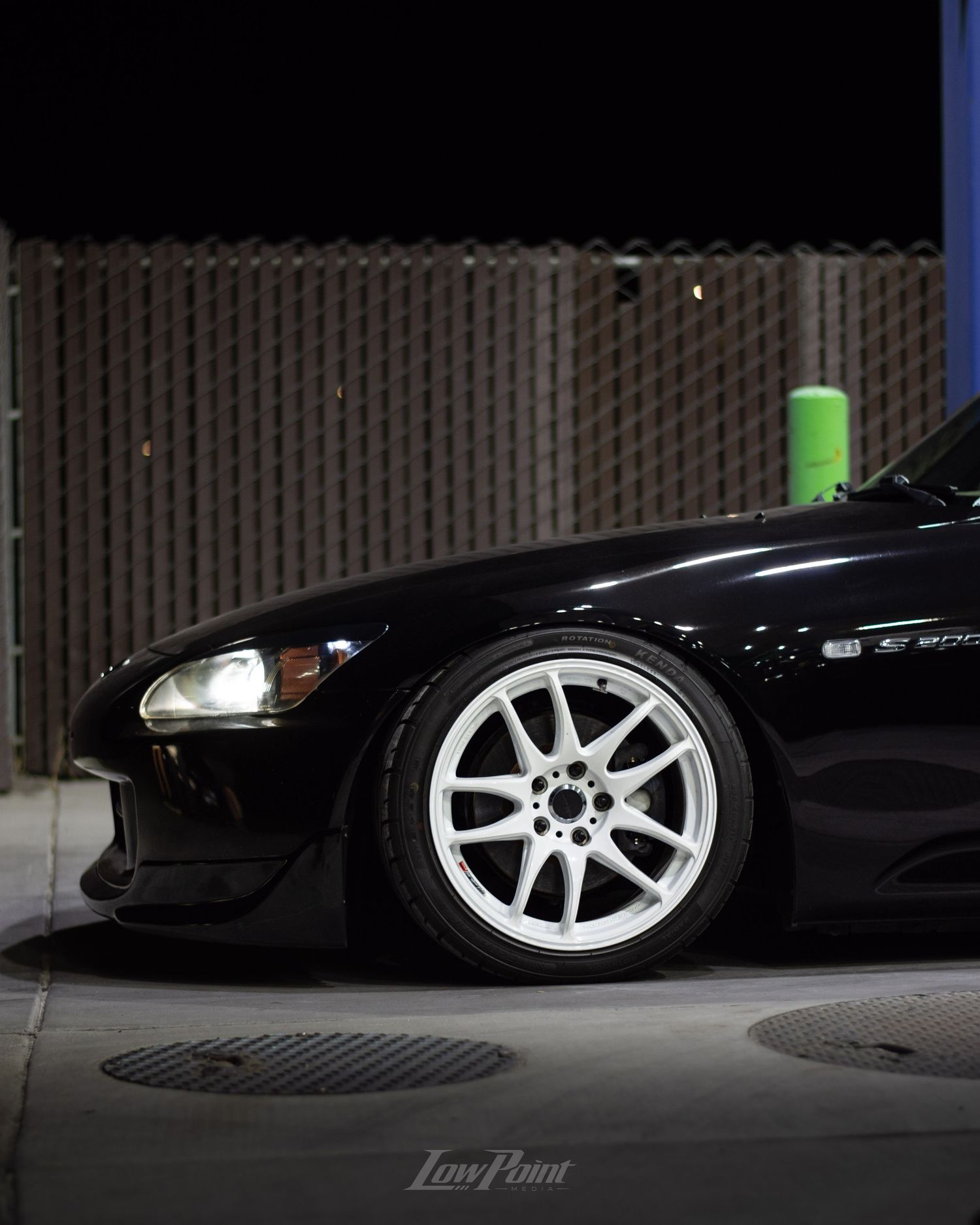Black Honda S2000 photographed at night at a gas pump with white Work wheels