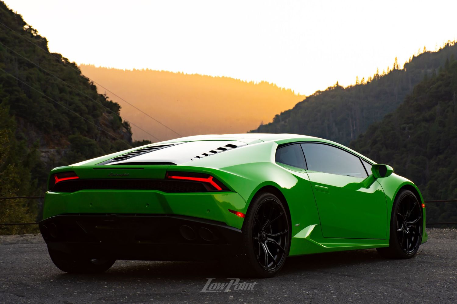 Green Lamborghini Huracan photographed with golden sunset mountains in the background