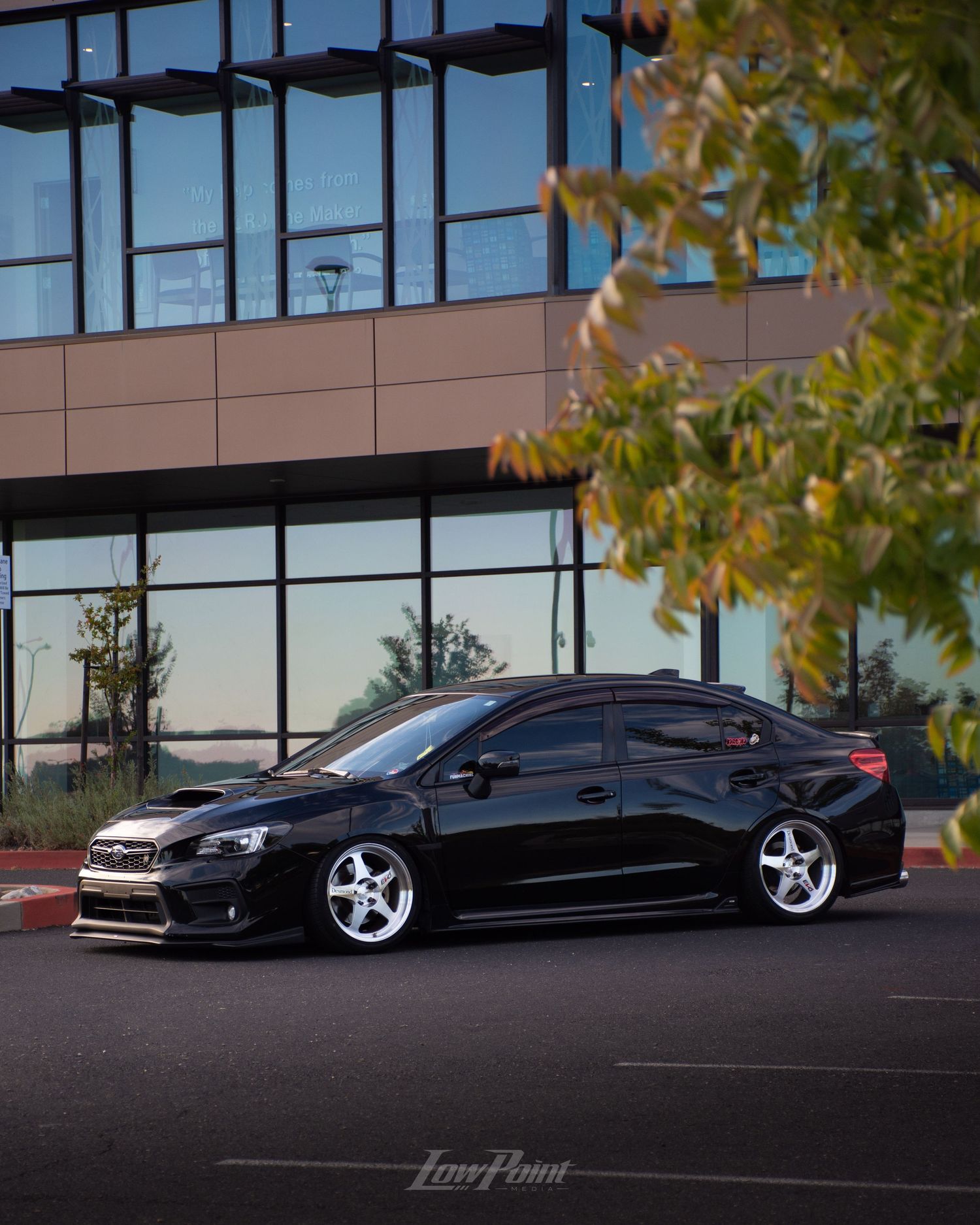 Black Subaru WRX photographed in front of modern building with large modern windows