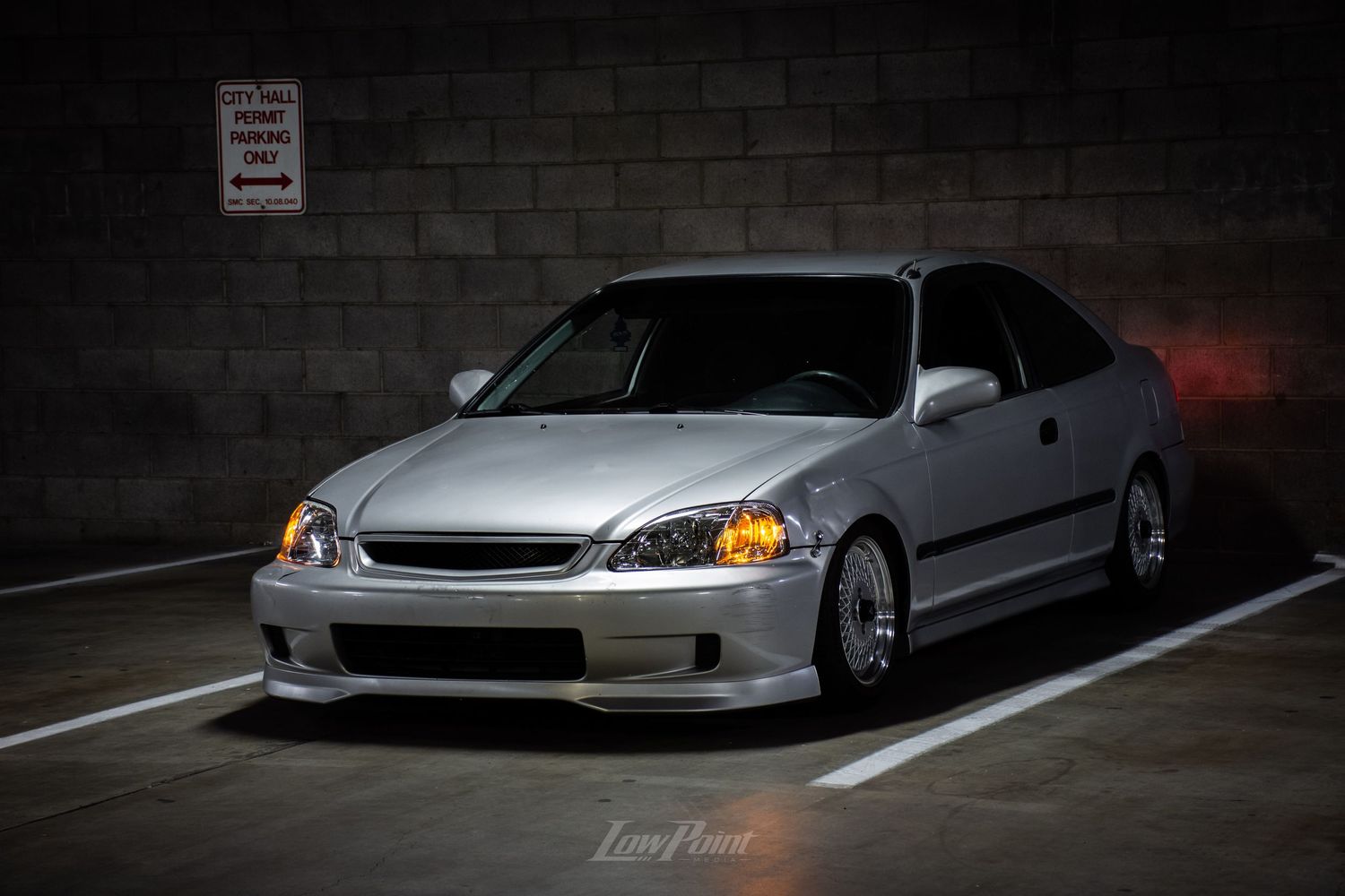 Silver Honda Civic photographed in parking garage at night with moody lighting