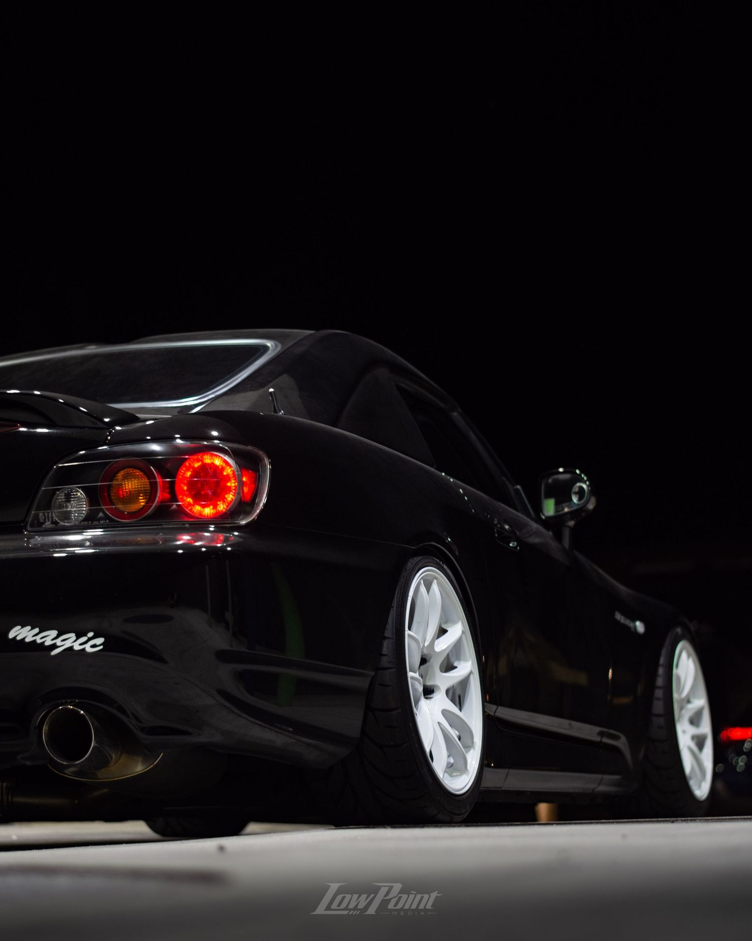 Black Honda S2000 photographed at night at a gas pump with white Work wheels